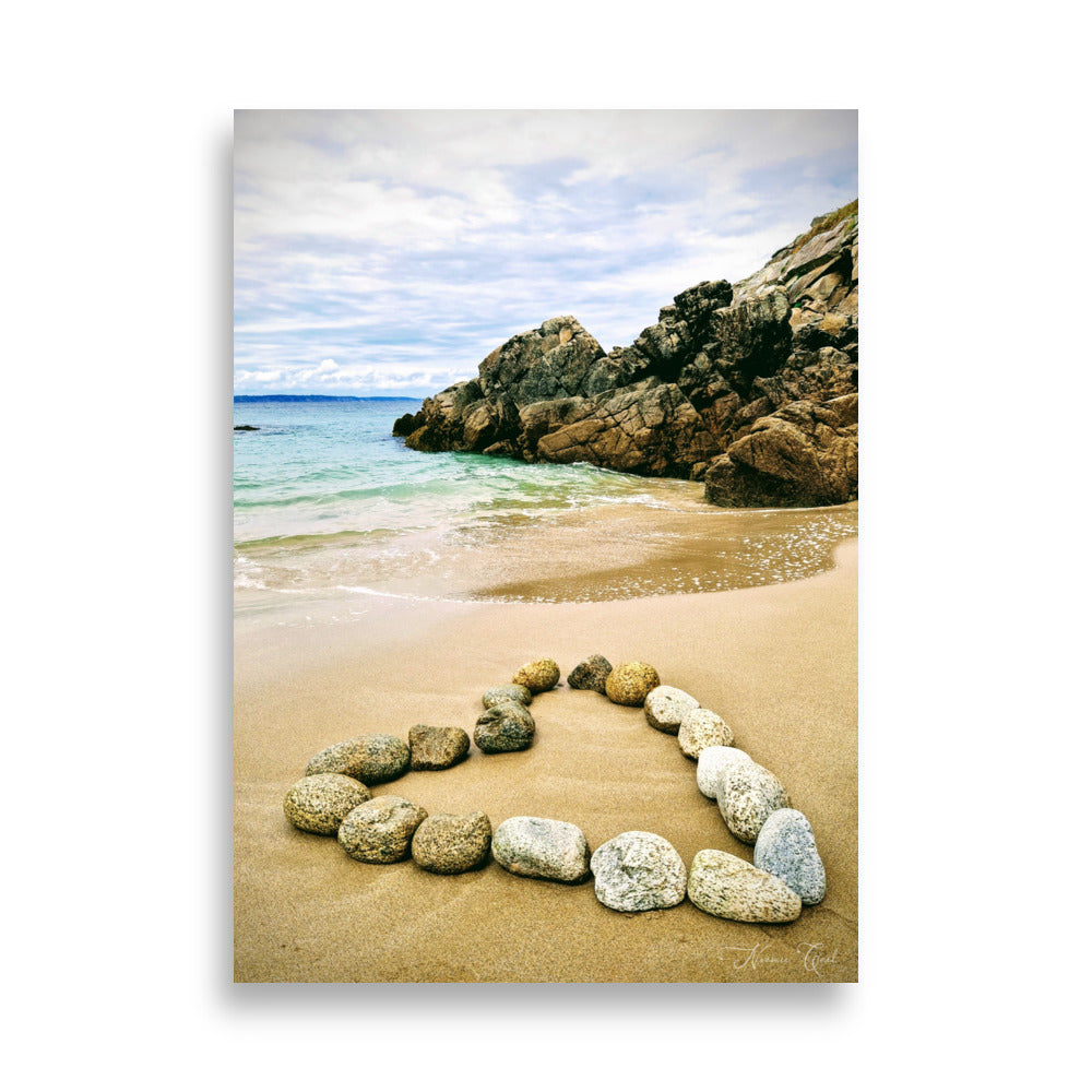 Photographie de plage avec des galets qui forme un coeur.