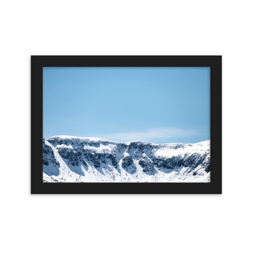 Photographie des montagnes enneigées du Cantal sous un ciel bleu ensoleillé