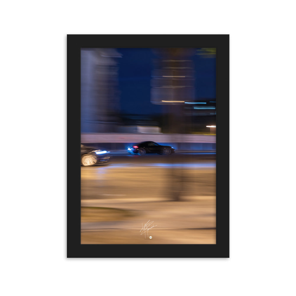 Photographie de la Place de l'Étoile capturant une Porsche au milieu de lumières floues de la circulation. La technique de pause longue crée un contraste saisissant entre mouvement et immobilité, illustrant l'effervescence parisienne.