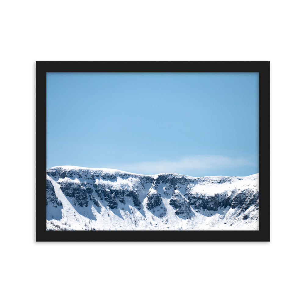 Photographie des montagnes enneigées du Cantal sous un ciel bleu ensoleillé