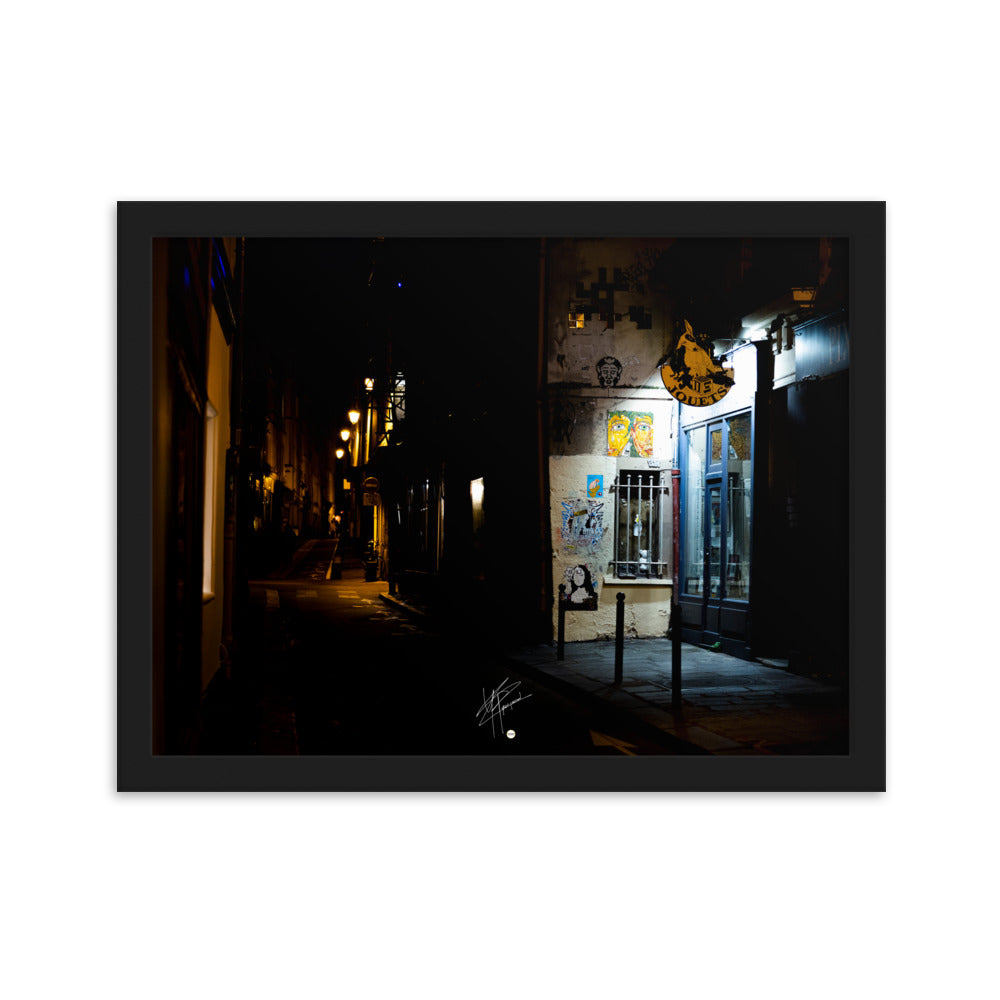 Photographie nocturne d'une rue parisienne, combinant éclats d'art urbain et lumière douce d'un magasin de jouets, évoquant la diversité et le charme artistique de la capitale.