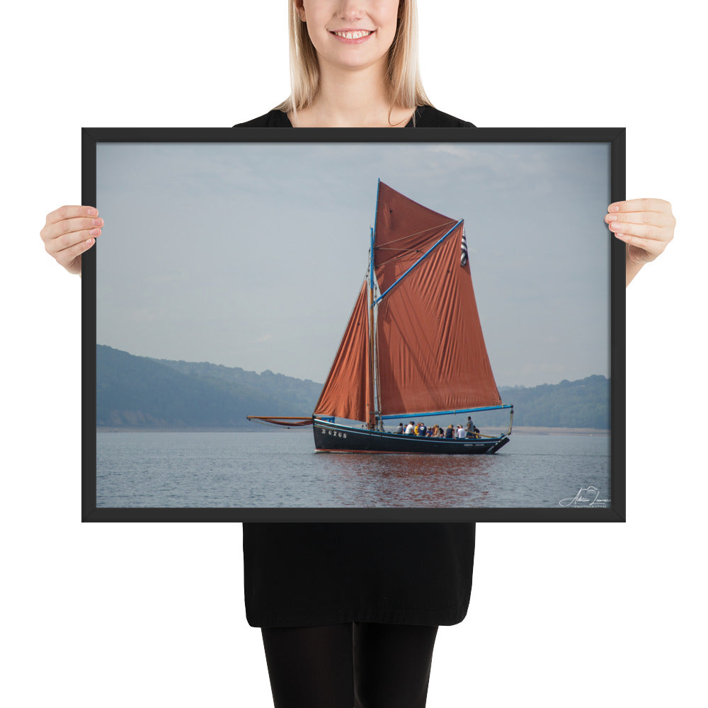 Affiche 'Le cap sur Brest', une image maritime pittoresque par Adrien Louraco, montrant un bateau à voile rouge naviguant à travers le port de Brest, combinant beauté naturelle et charme culturel breton dans une œuvre d'art mural inspirante.