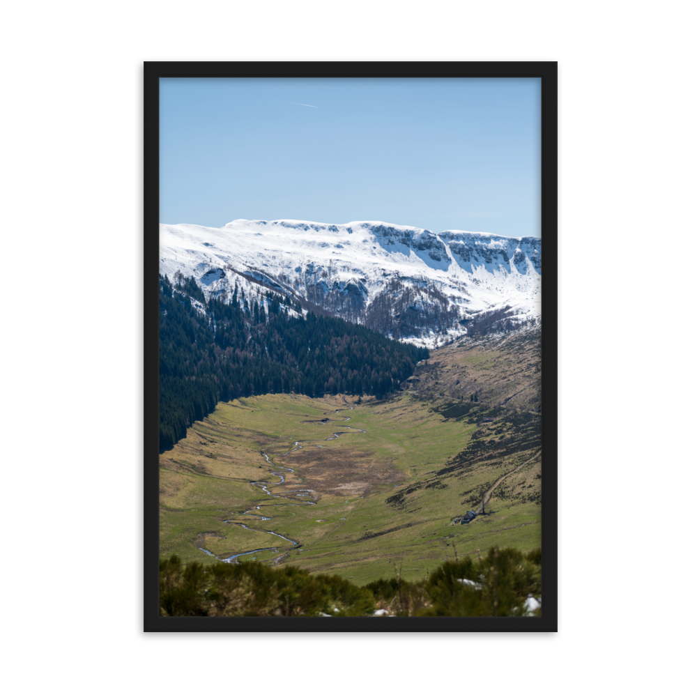 Poster d'une vallée verdoyante avec des montagnes enneigées en arrière-plan, situées dans le Cantal