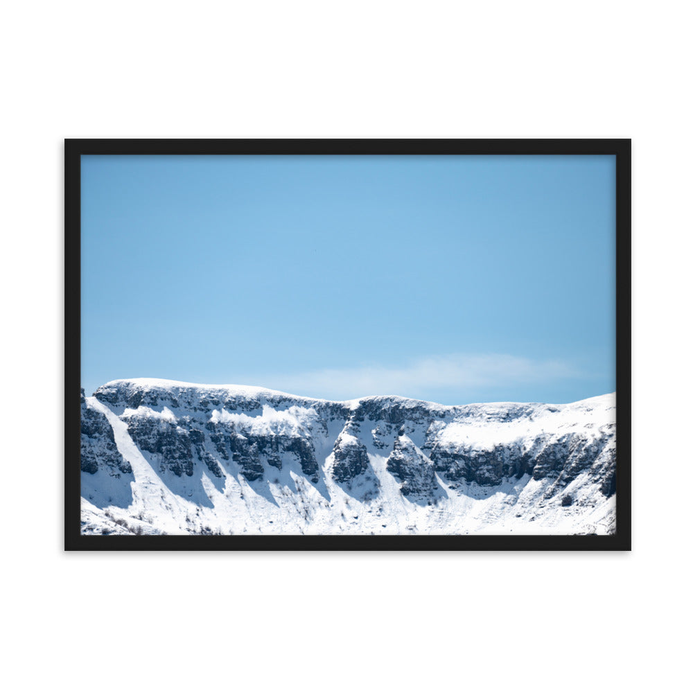 Photographie des montagnes enneigées du Cantal sous un ciel bleu ensoleillé