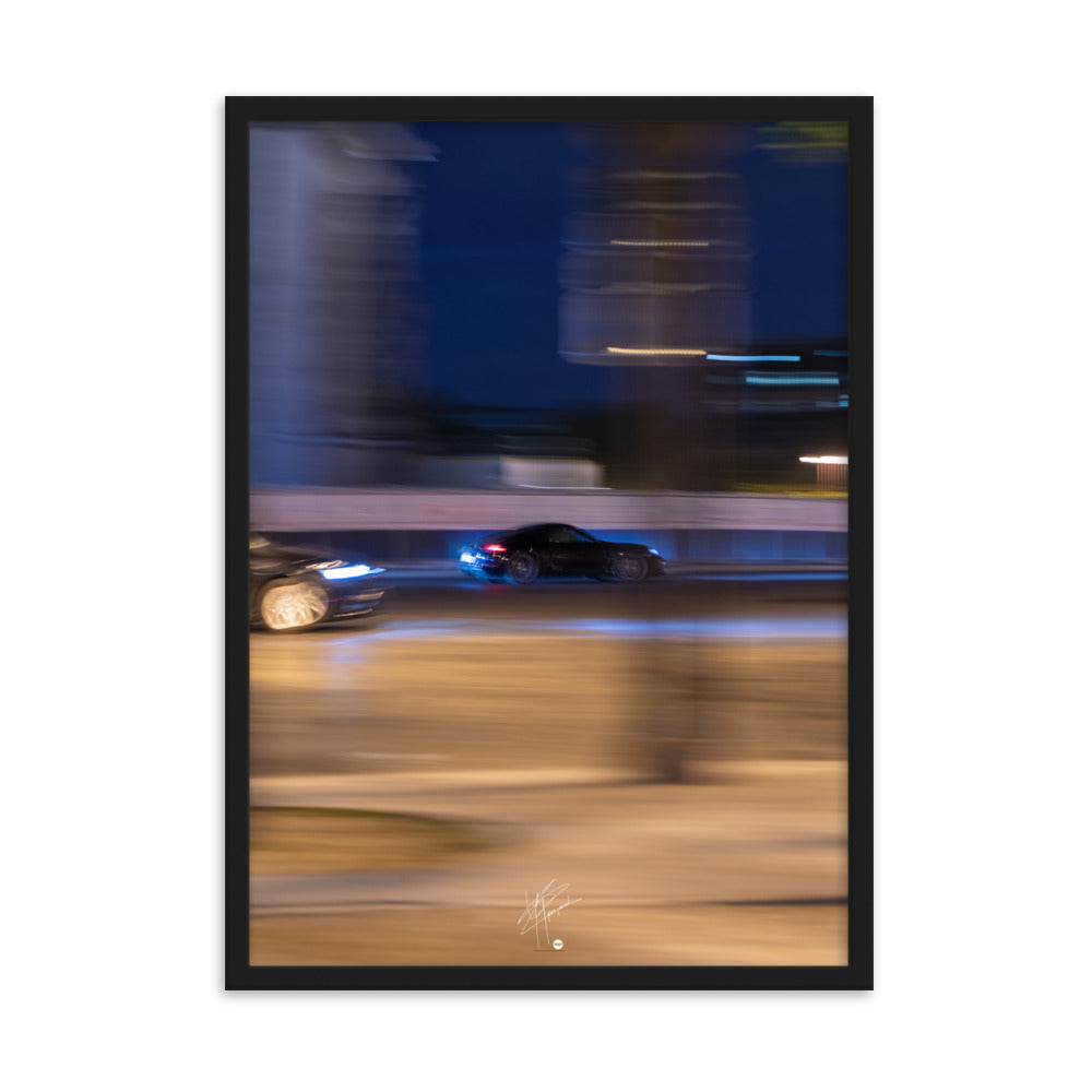 Photographie de la Place de l'Étoile capturant une Porsche au milieu de lumières floues de la circulation. La technique de pause longue crée un contraste saisissant entre mouvement et immobilité, illustrant l'effervescence parisienne.