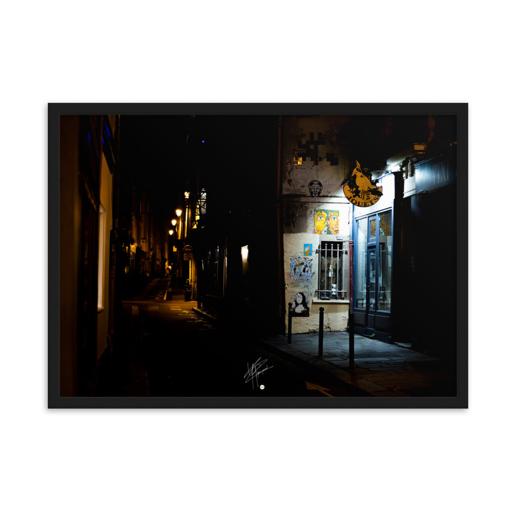 Photographie nocturne d'une rue parisienne, combinant éclats d'art urbain et lumière douce d'un magasin de jouets, évoquant la diversité et le charme artistique de la capitale.