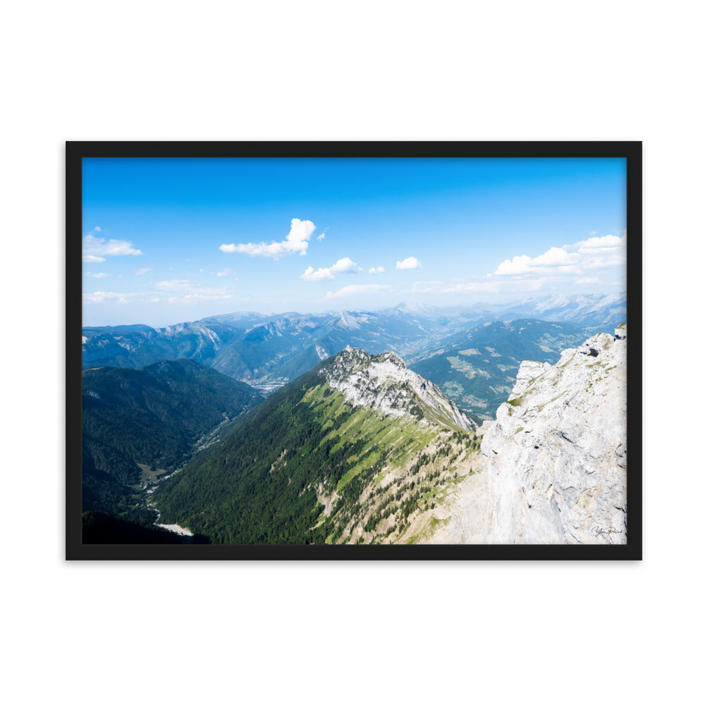 Photographie panoramique des Alpes avec montagnes robustes, vallées verdoyantes, nuages flottants et ciel bleu azur.