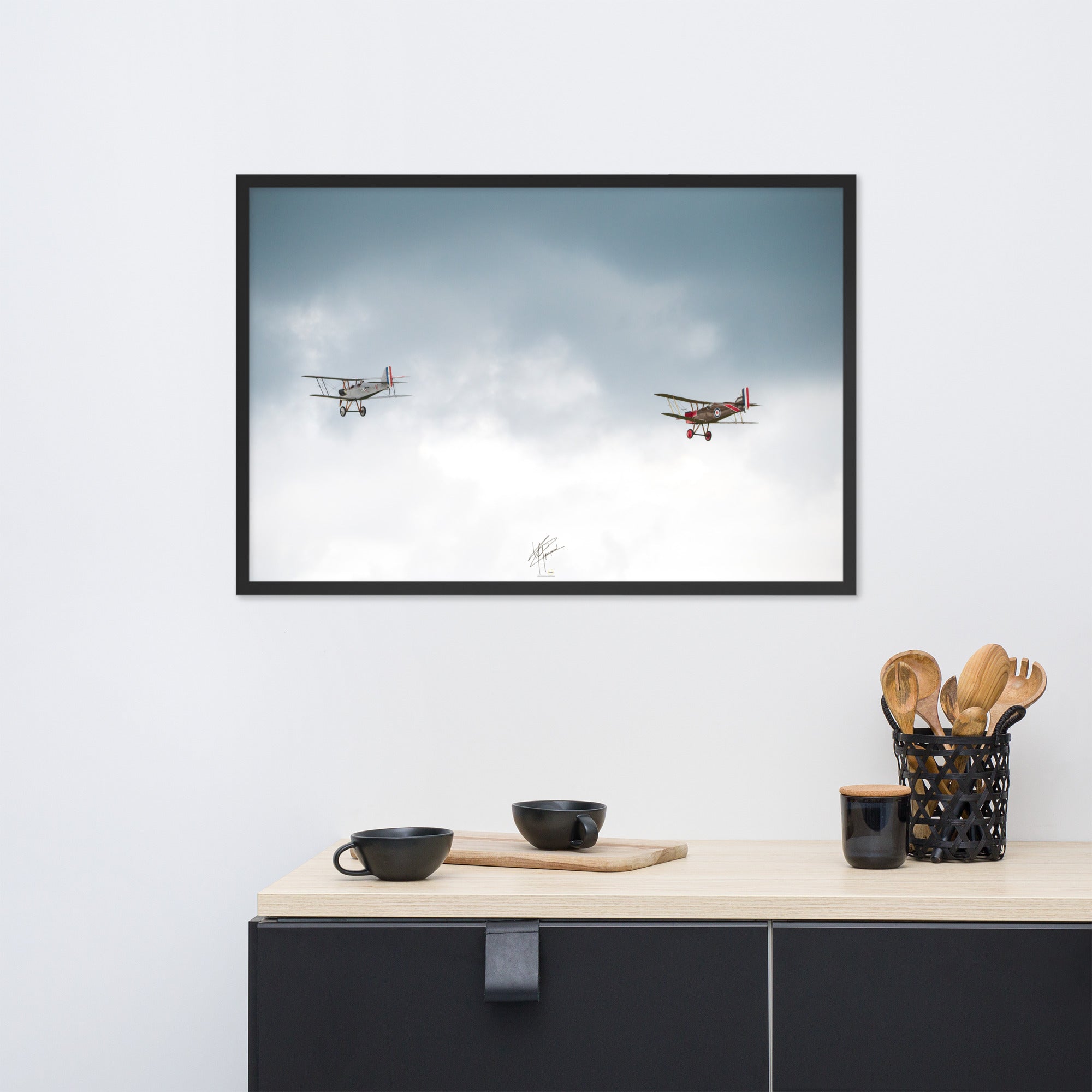 Deux avions de combat de la Première Guerre Mondiale s'élevant contre un ciel gris-blanc, encapsulant l'héroïsme de l'époque. Poster encadré de haute qualité signé 'Tagazou'.