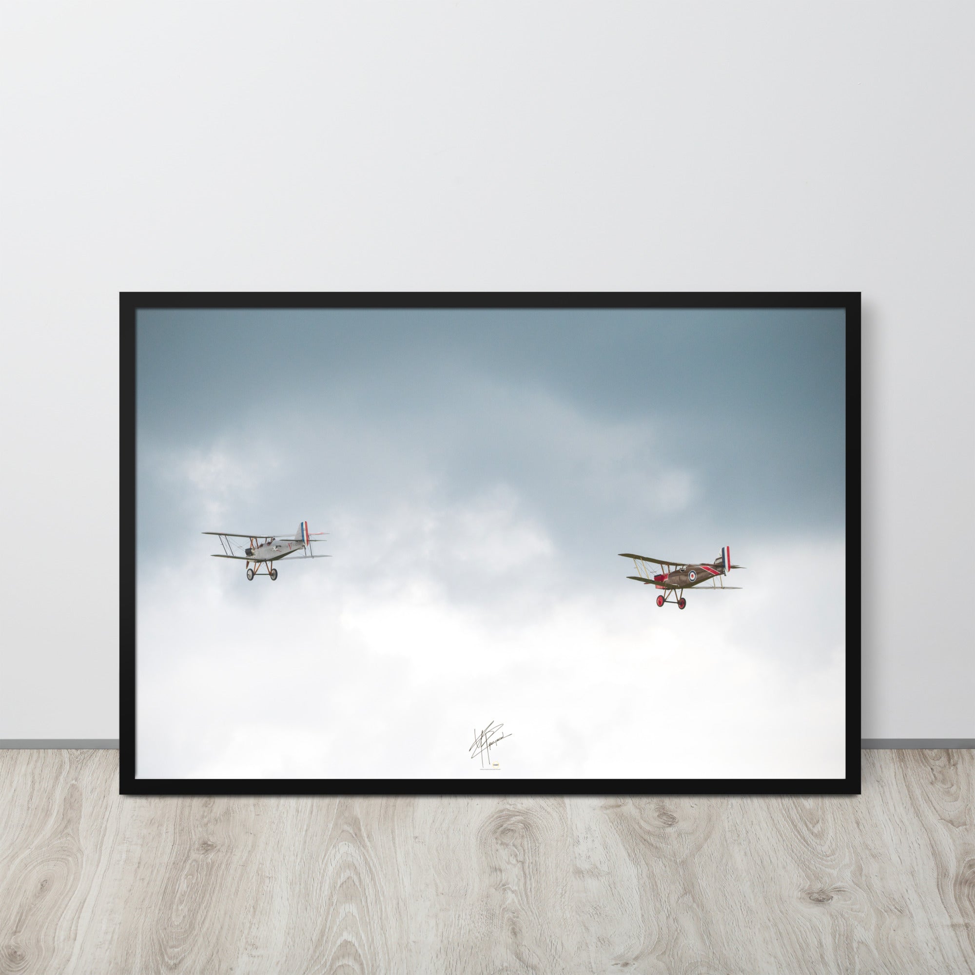 Deux avions de combat de la Première Guerre Mondiale s'élevant contre un ciel gris-blanc, encapsulant l'héroïsme de l'époque. Poster encadré de haute qualité signé 'Tagazou'.