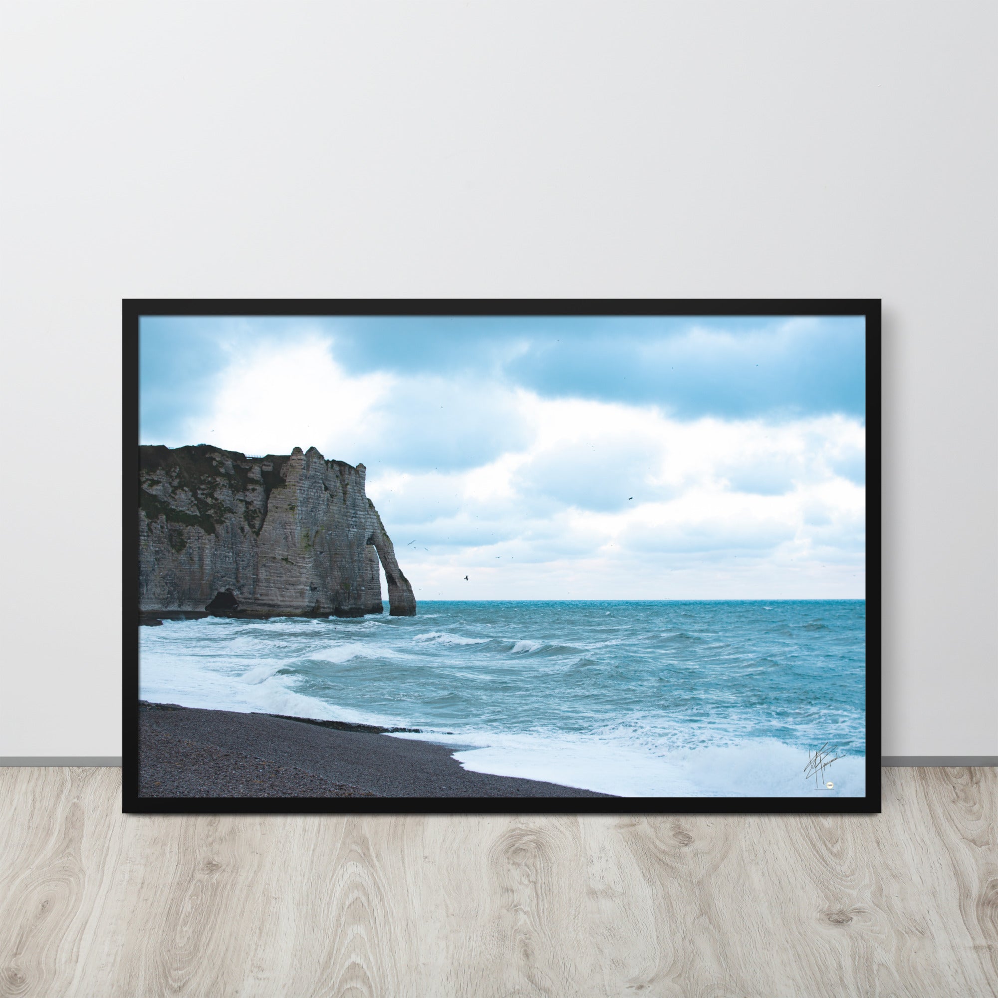 Photographie apaisante de la plage d'Etretat, où la mer caresse le rivage sous un ciel clair. Une représentation parfaite de la tranquillité et de la beauté naturelle de la côte normande.