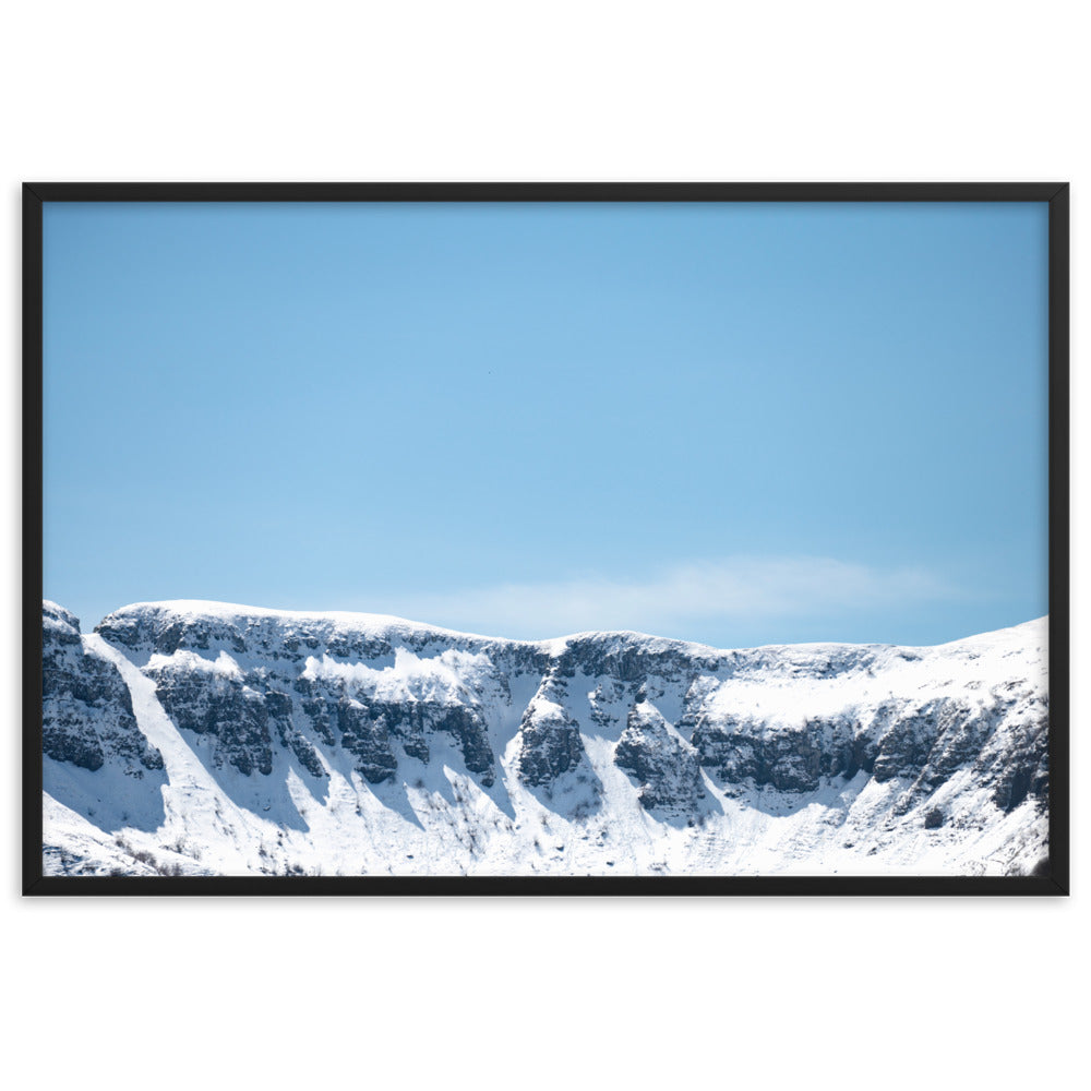 Photographie des montagnes enneigées du Cantal sous un ciel bleu ensoleillé