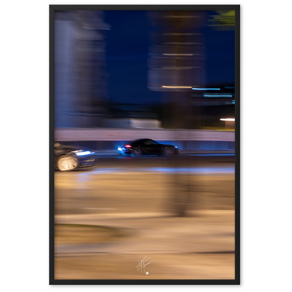 Photographie de la Place de l'Étoile capturant une Porsche au milieu de lumières floues de la circulation. La technique de pause longue crée un contraste saisissant entre mouvement et immobilité, illustrant l'effervescence parisienne.