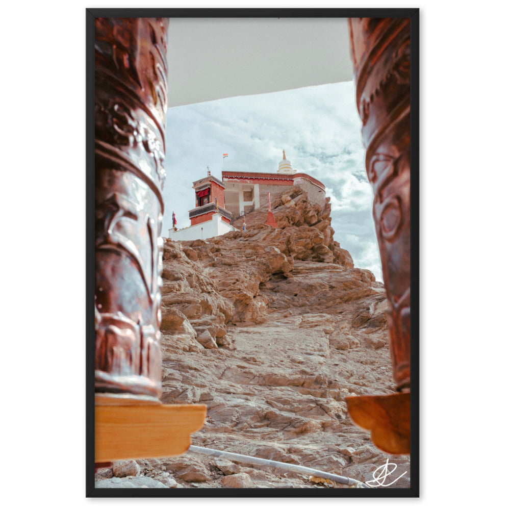 Photographie 'Le Temple sur la Montagne' par Ilan Shoham, montrant le monastère de Thiksey perché sur les hauteurs du Ladakh, encadré par des rouleaux à prières, avec un ciel azur en arrière-plan.