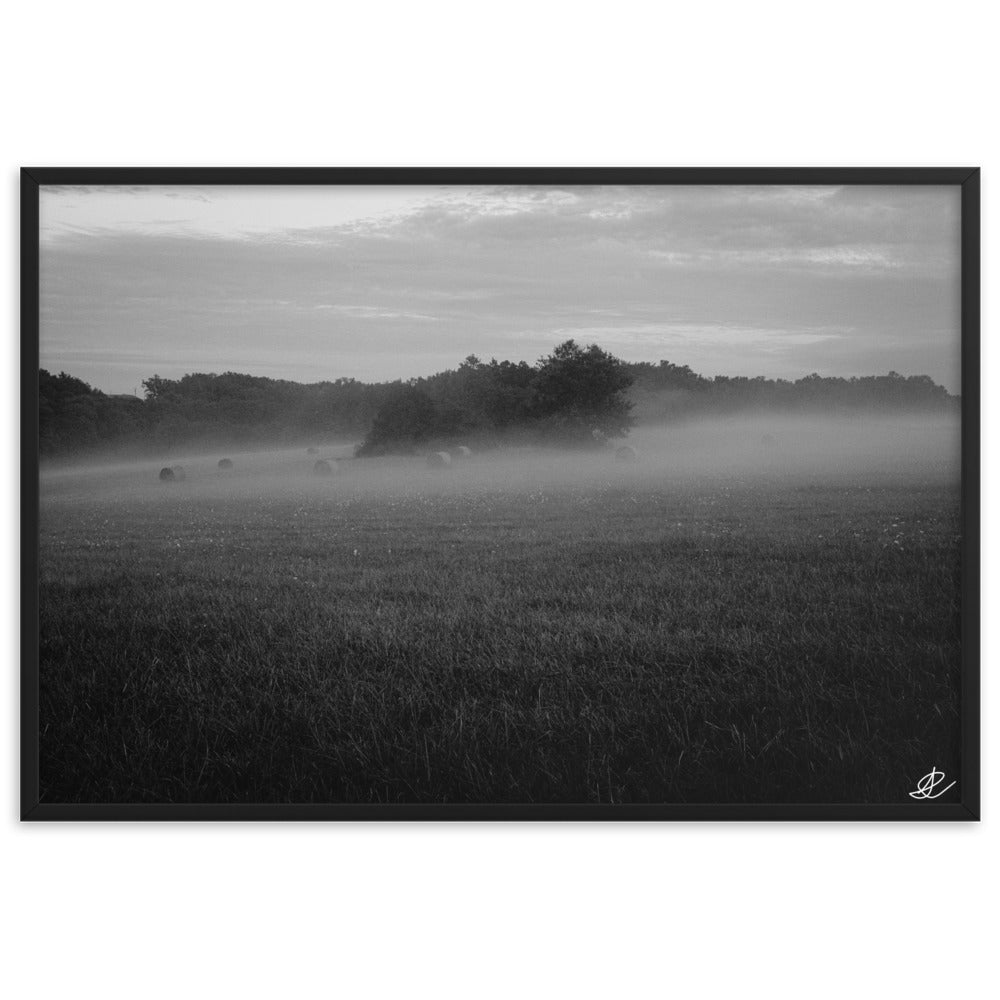 Photographie noir et blanc 'Brouillard' par Ilan Shoham, mettant en scène un paisible champ tourangeau où des ballots de paille émergent majestueusement du brouillard, incarnant la sérénité et la beauté mystique de la campagne française.