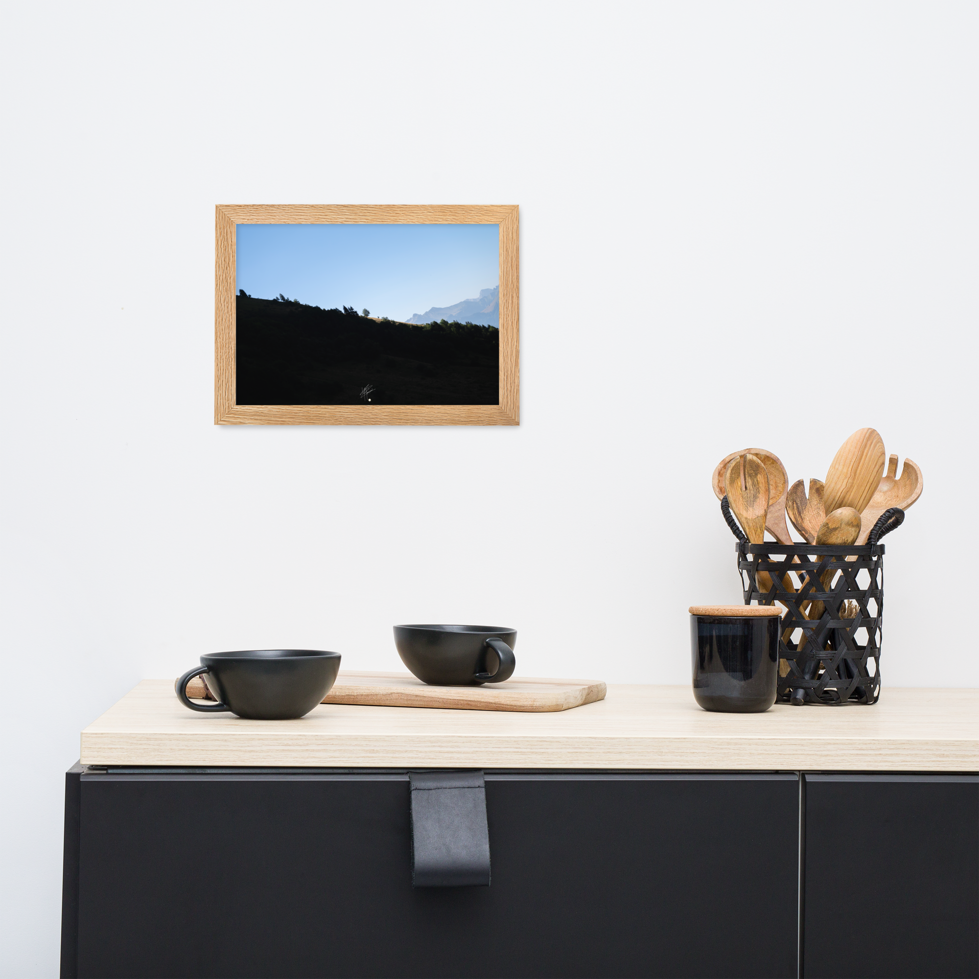 Poster encadré 'Le Tournis', mettant en scène un arbre solitaire éclairé par le soleil sur un flanc de montagne sombre, capturant l'essence du mystère et de la lumière alpine.