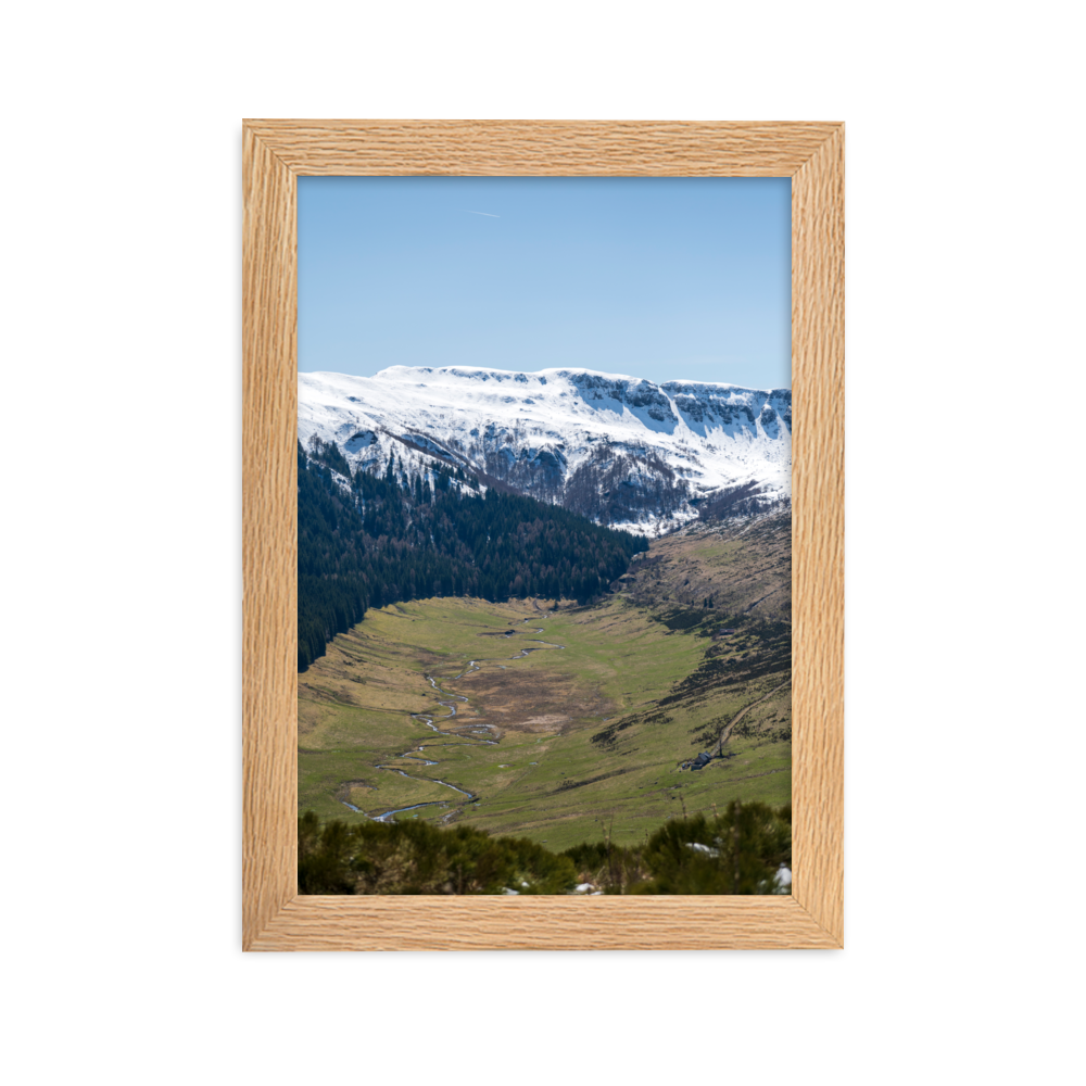 Poster d'une vallée verdoyante avec des montagnes enneigées en arrière-plan, situées dans le Cantal