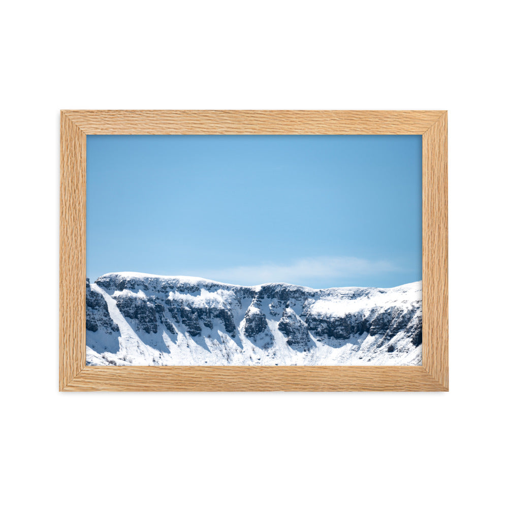 Photographie des montagnes enneigées du Cantal sous un ciel bleu ensoleillé