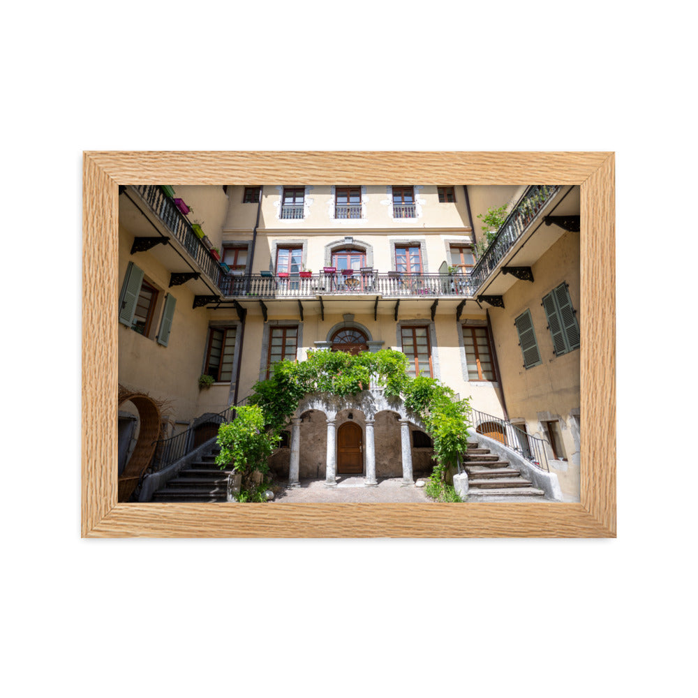 Photographie d'un bâtiment traditionnel italien avec escaliers en spirale et plantes suspendues, encadrée en chêne massif.