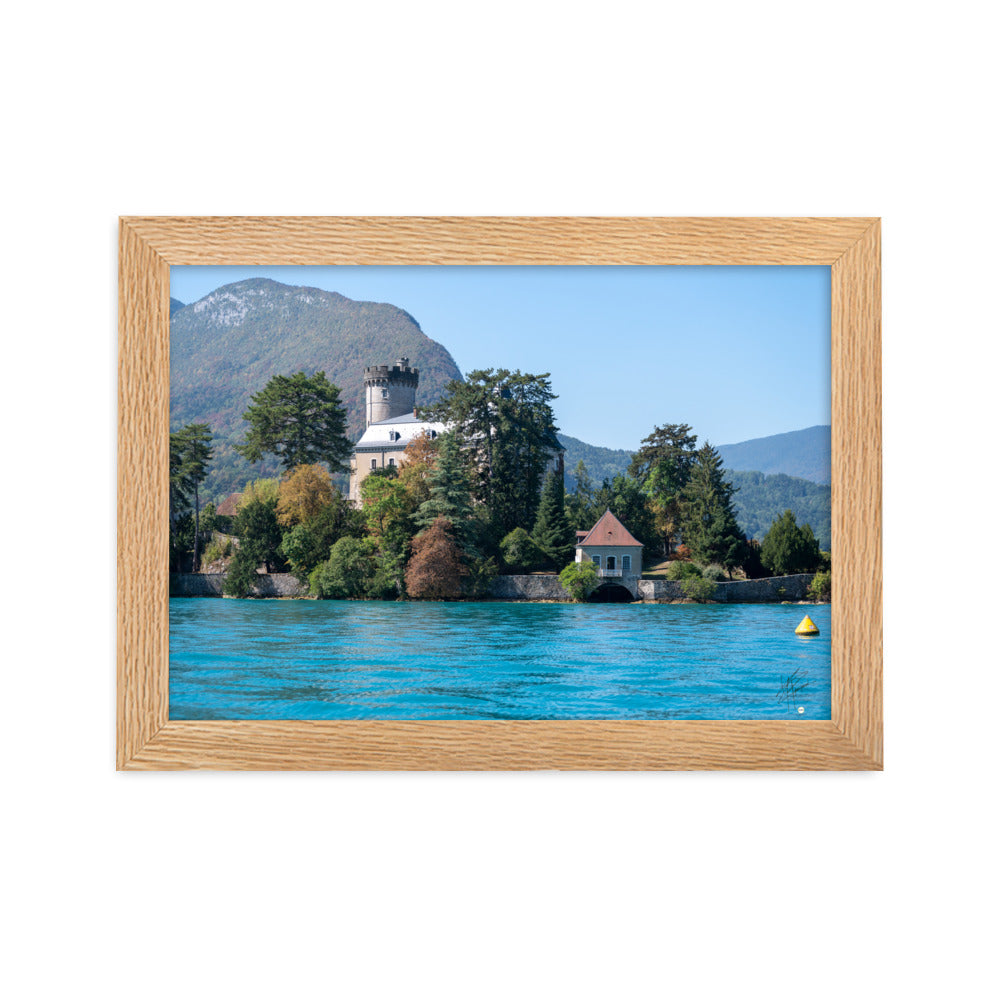 Vue panoramique du Château de Duingt, dominé par des montagnes, avec le Lac d'Annecy reflétant l'édifice, encadré en chêne.