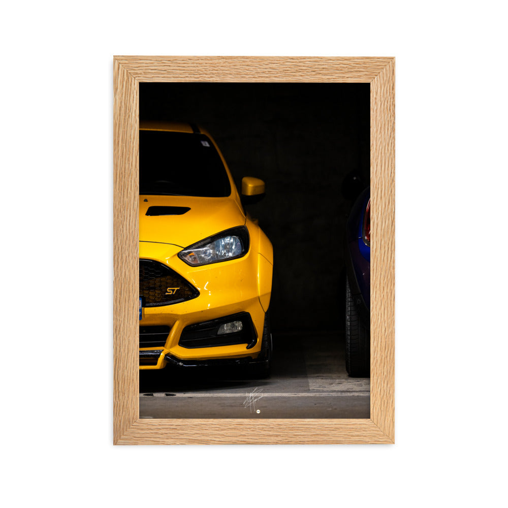 Ford Focus ST en teinte jaune brillante, éclairée dans un parking souterrain sombre, encadrée en bois de chêne.