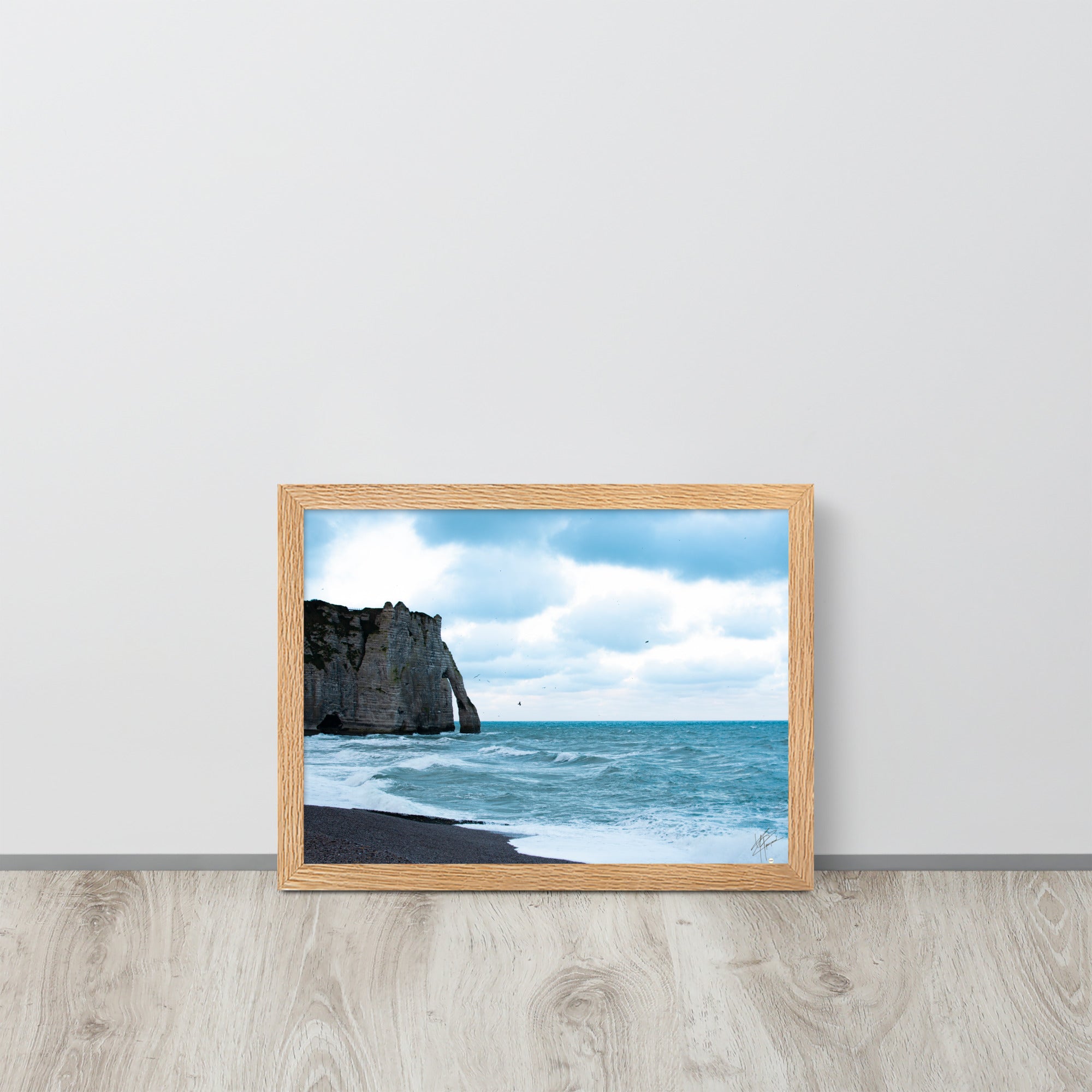 Photographie apaisante de la plage d'Etretat, où la mer caresse le rivage sous un ciel clair. Une représentation parfaite de la tranquillité et de la beauté naturelle de la côte normande.