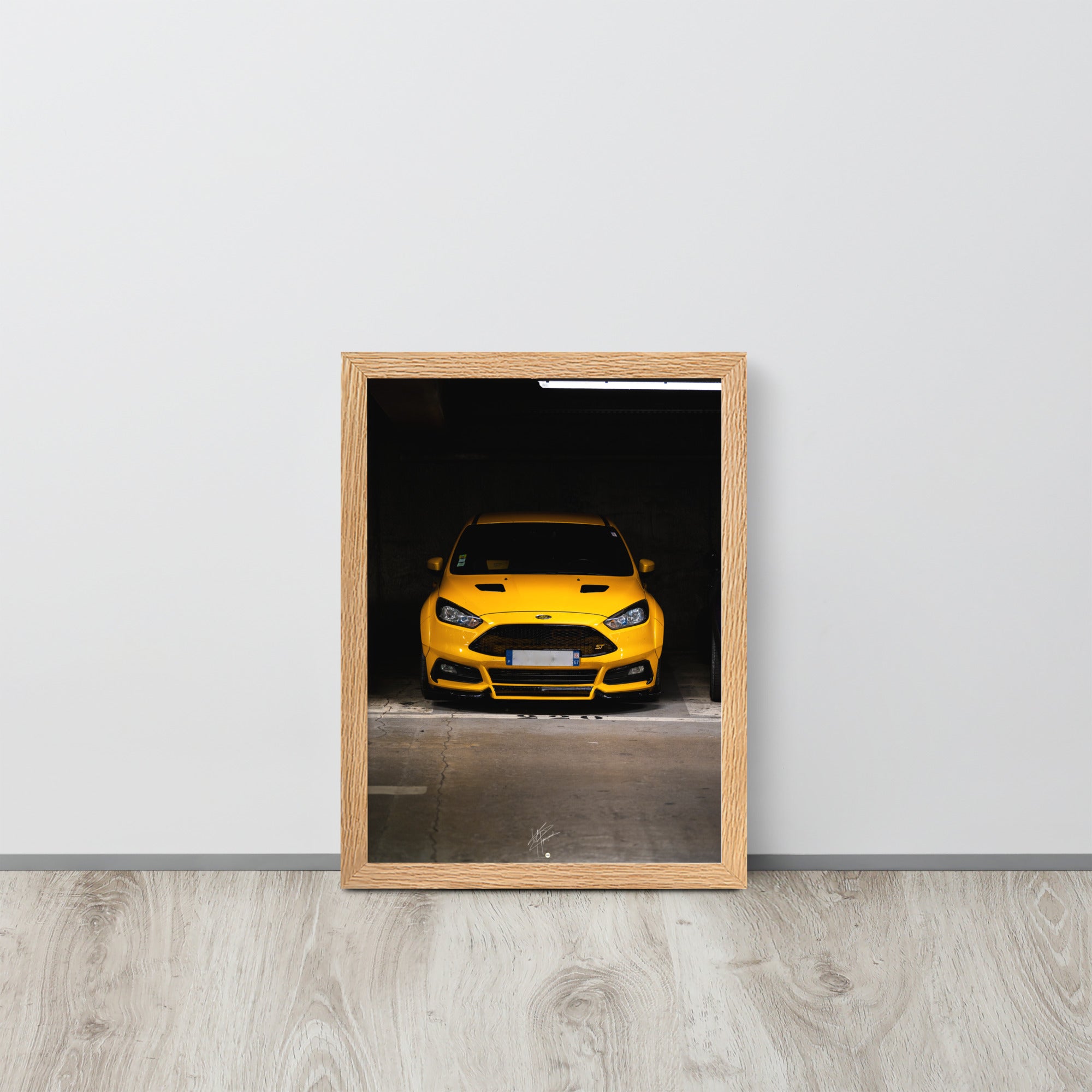 Vue frontale d'une Ford Focus ST en éclatant jaune, mise en lumière dans un parking souterrain avec un éclairage distinctif, encadrement en chêne.