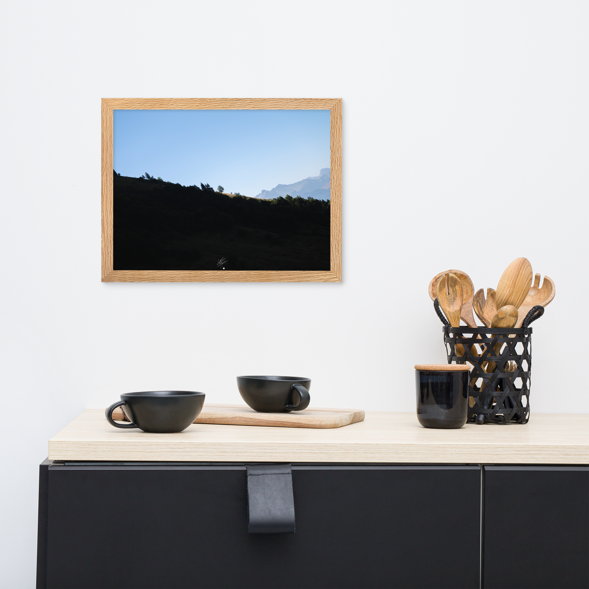 Poster encadré 'Le Tournis', mettant en scène un arbre solitaire éclairé par le soleil sur un flanc de montagne sombre, capturant l'essence du mystère et de la lumière alpine.