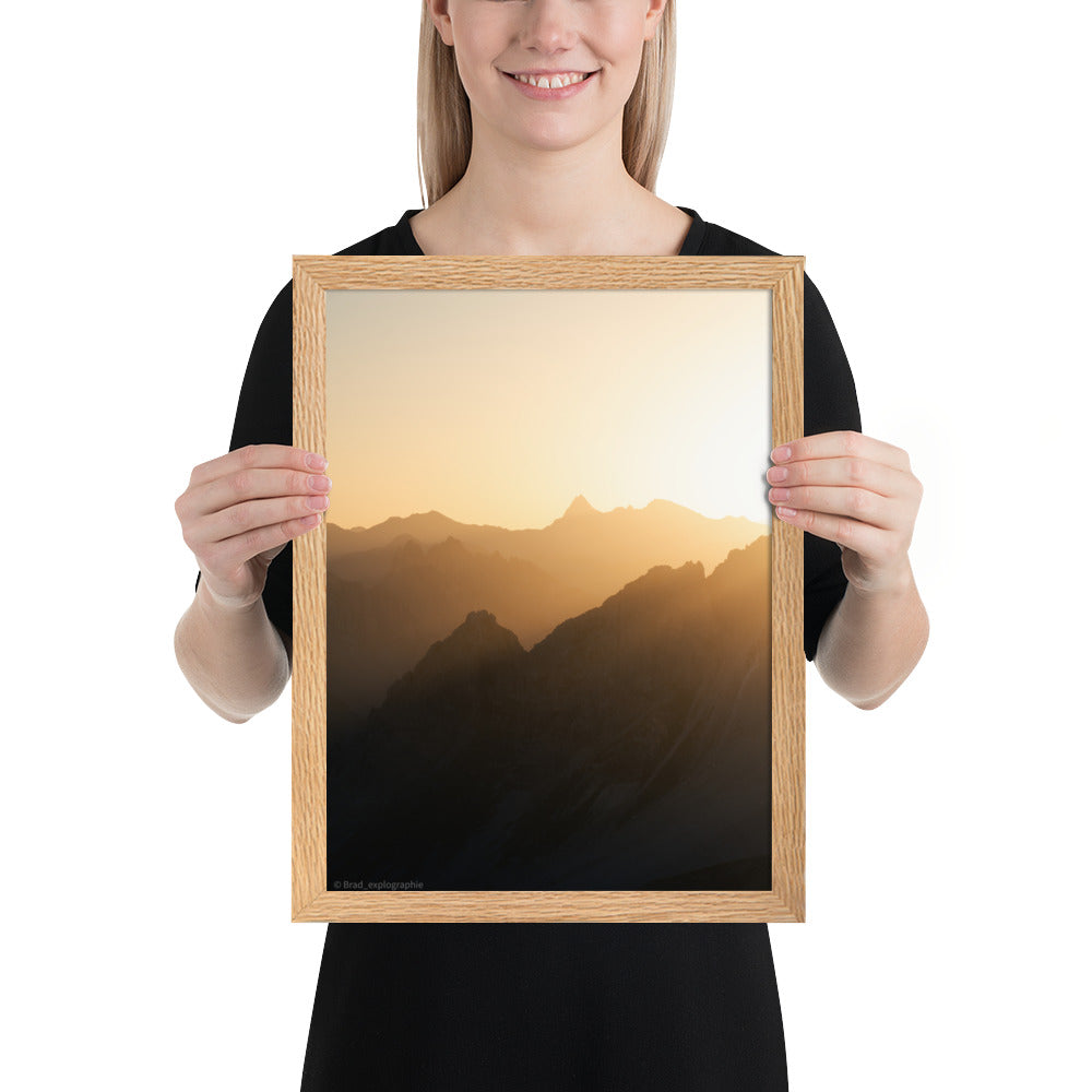 Lever du soleil illuminant des montagnes imposantes, photographié par Brad_explographie, présenté dans un cadre élégant.