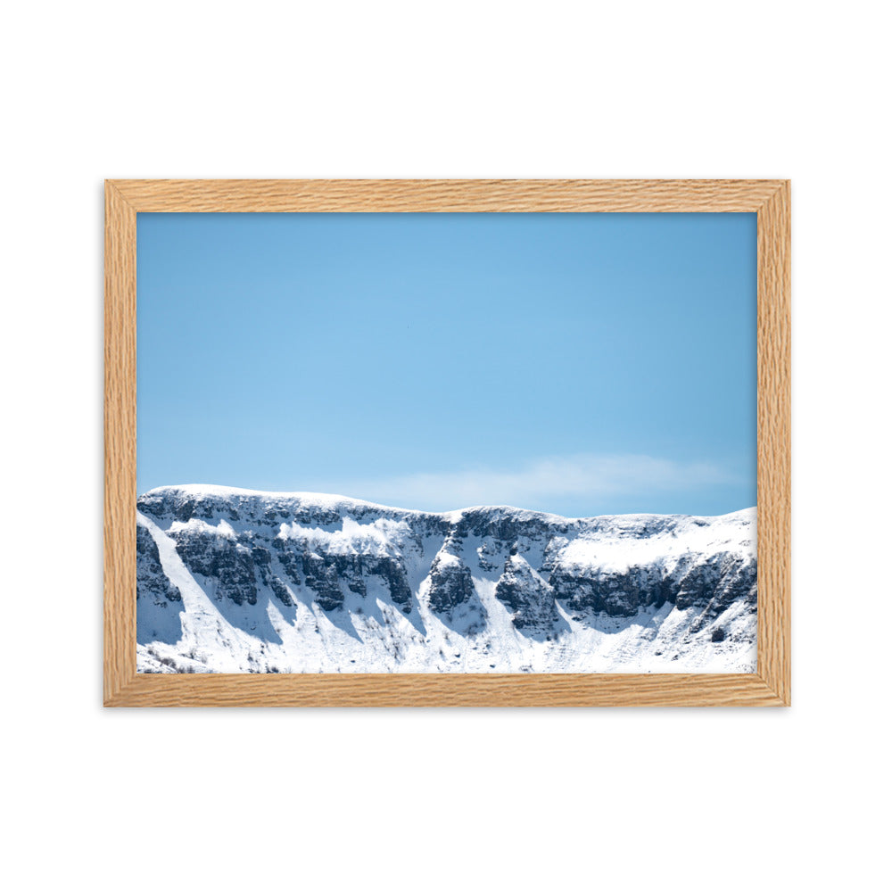 Photographie des montagnes enneigées du Cantal sous un ciel bleu ensoleillé