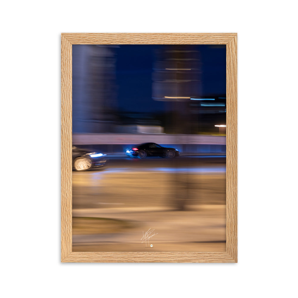 Photographie de la Place de l'Étoile capturant une Porsche au milieu de lumières floues de la circulation. La technique de pause longue crée un contraste saisissant entre mouvement et immobilité, illustrant l'effervescence parisienne.