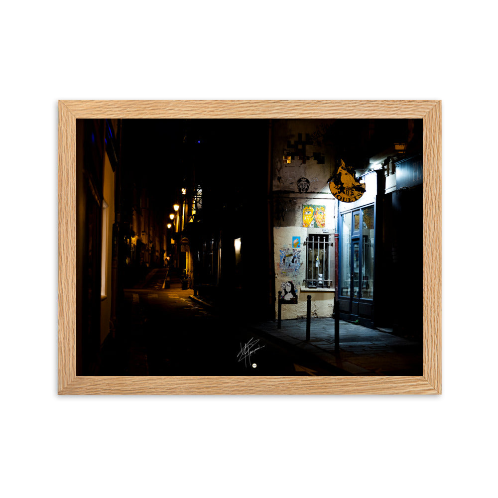 Photographie nocturne d'une rue parisienne, combinant éclats d'art urbain et lumière douce d'un magasin de jouets, évoquant la diversité et le charme artistique de la capitale.