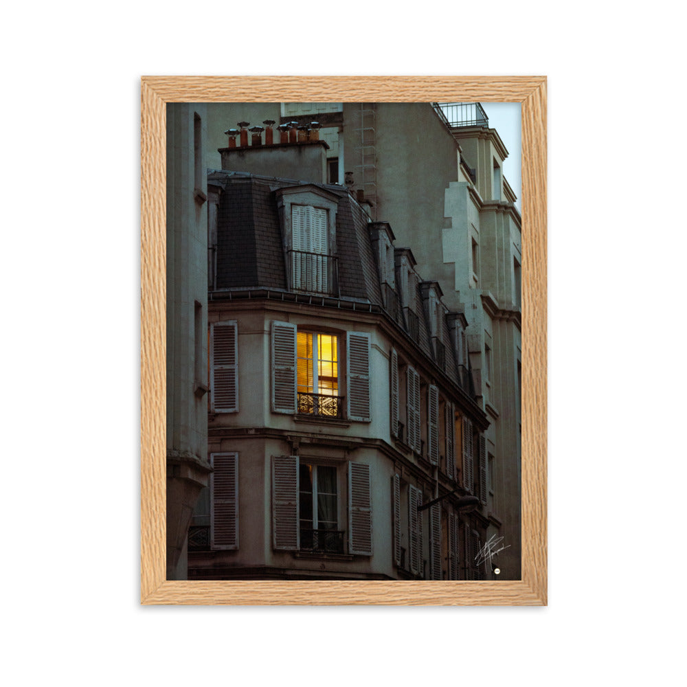 Photographie nocturne d'un bâtiment parisien vintage. Une fenêtre illuminée projette une lumière douce et chaleureuse, évoquant l'intimité d'un foyer parisien.