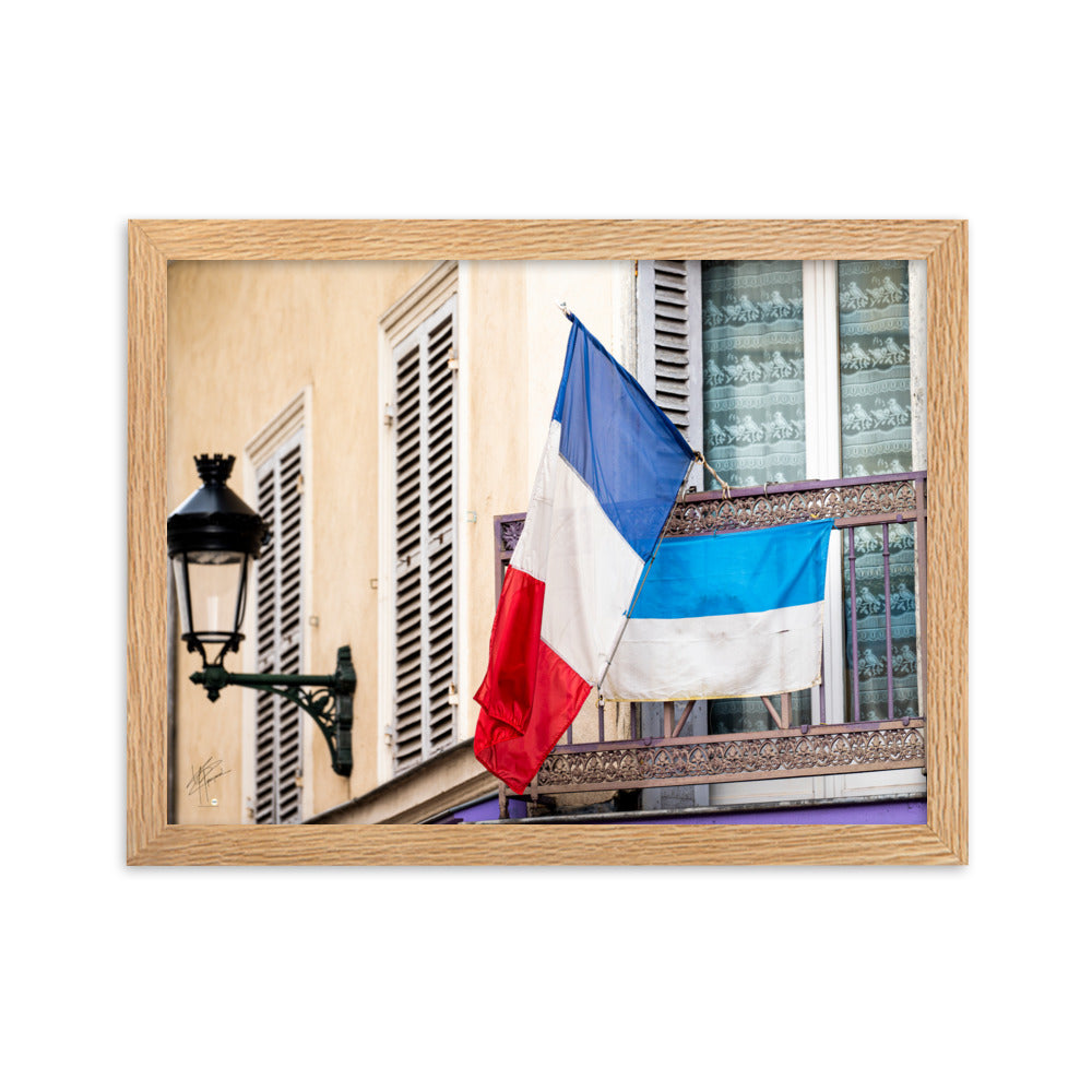 Photographie du drapeau tricolore français suspendu à un garde-corps métallique, représentant à la fois la tradition et la modernité, encadrée pour une mise en valeur murale.