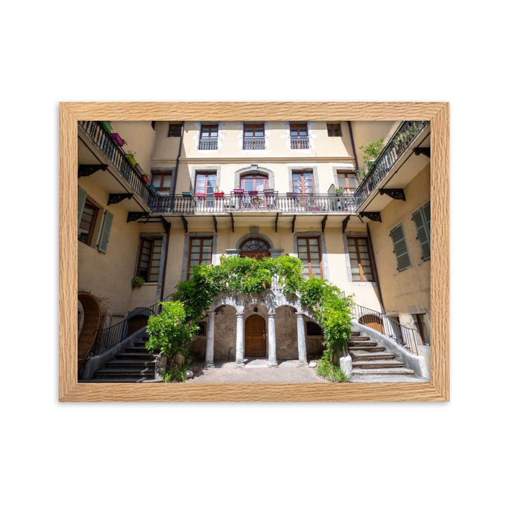 Photographie d'un bâtiment traditionnel italien avec escaliers en spirale et plantes suspendues, encadrée en chêne massif.