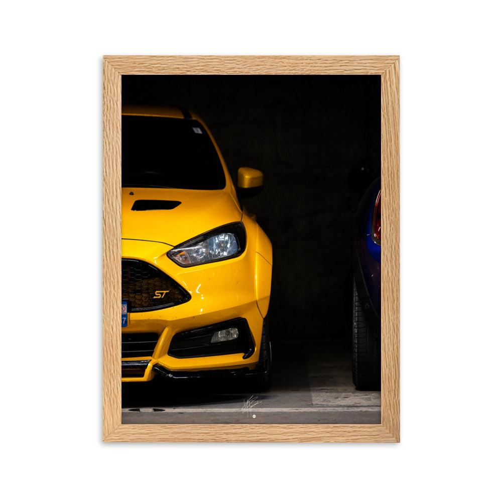 Ford Focus ST en teinte jaune brillante, éclairée dans un parking souterrain sombre, encadrée en bois de chêne.