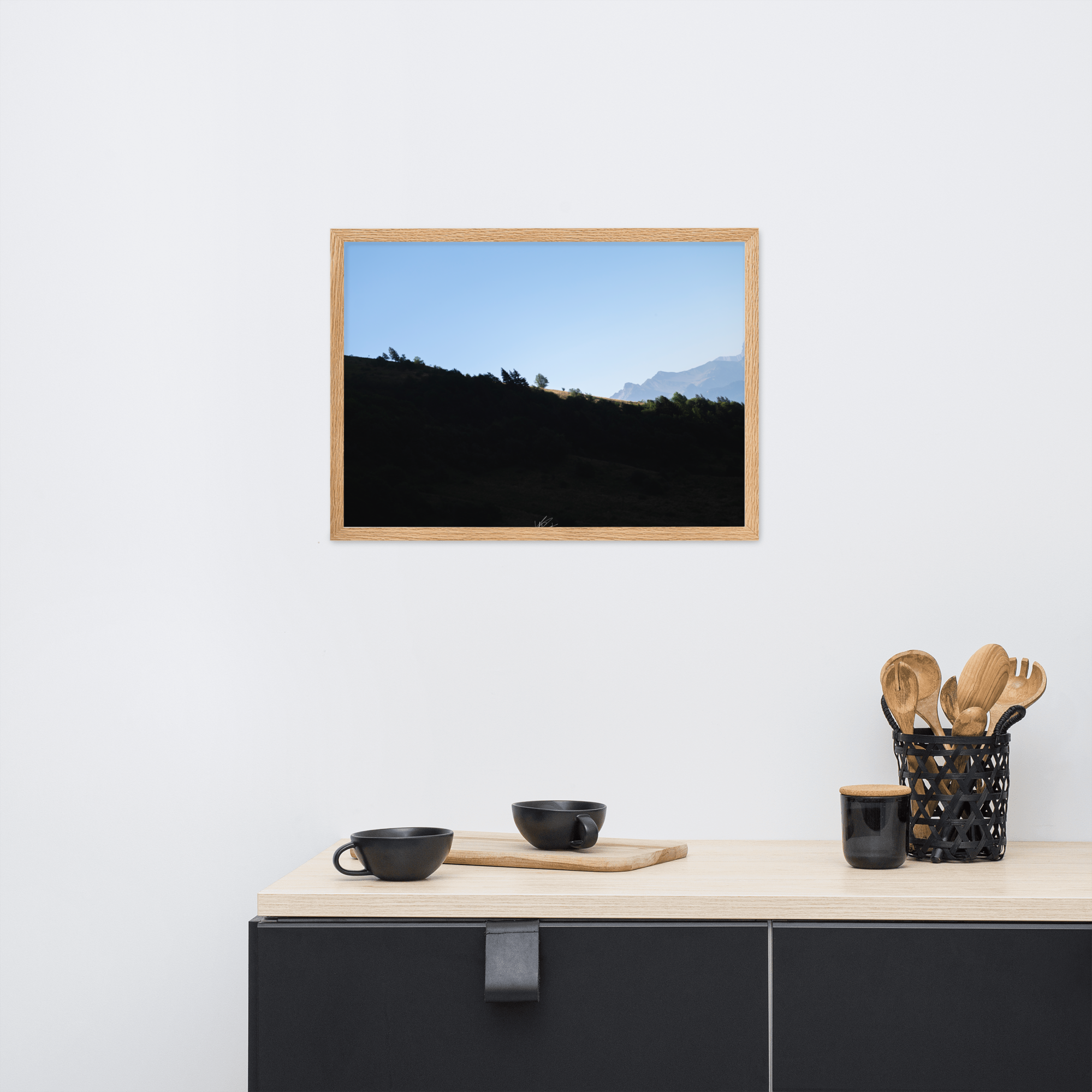 Poster encadré 'Le Tournis', mettant en scène un arbre solitaire éclairé par le soleil sur un flanc de montagne sombre, capturant l'essence du mystère et de la lumière alpine.