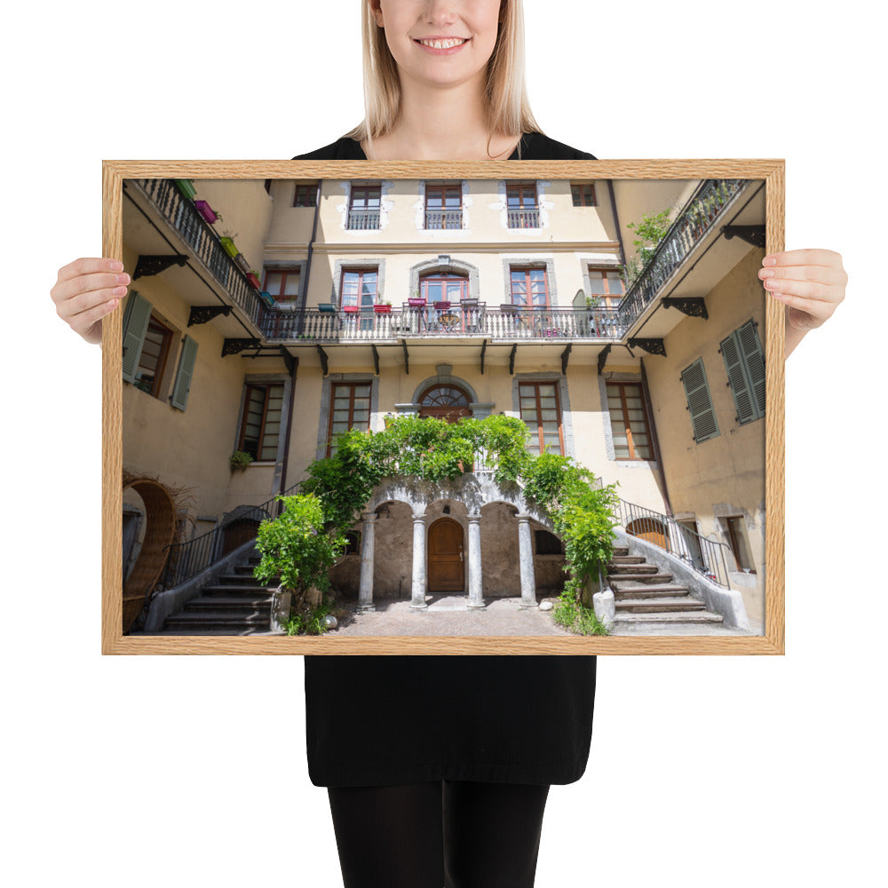 Photographie d'un bâtiment traditionnel italien avec escaliers en spirale et plantes suspendues, encadrée en chêne massif.