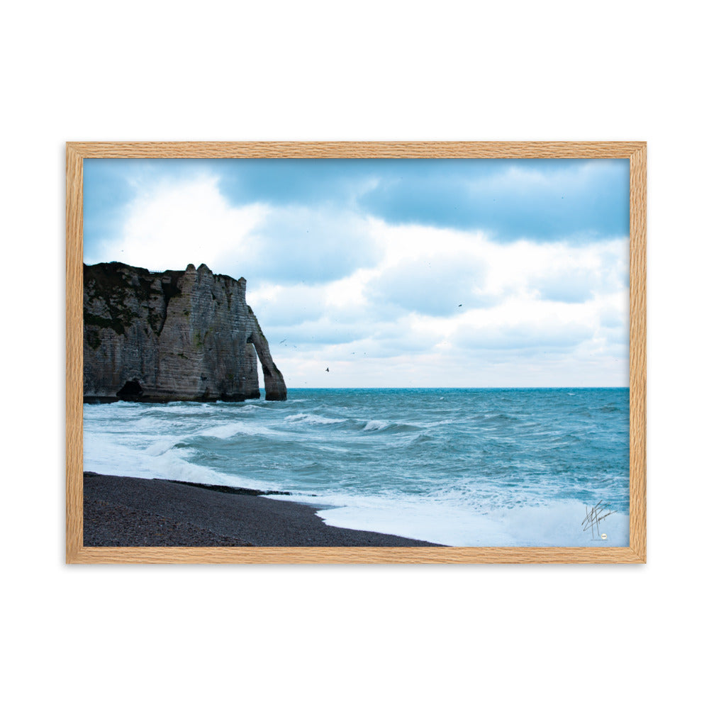 Photographie apaisante de la plage d'Etretat, où la mer caresse le rivage sous un ciel clair. Une représentation parfaite de la tranquillité et de la beauté naturelle de la côte normande.