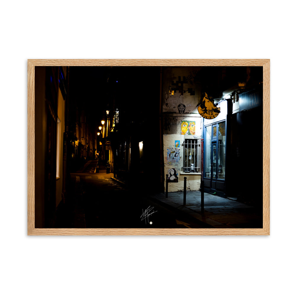 Photographie nocturne d'une rue parisienne, combinant éclats d'art urbain et lumière douce d'un magasin de jouets, évoquant la diversité et le charme artistique de la capitale.