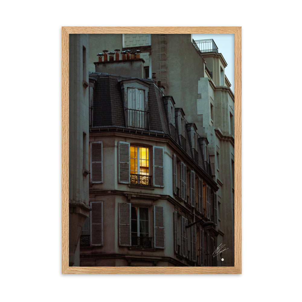 Photographie nocturne d'un bâtiment parisien vintage. Une fenêtre illuminée projette une lumière douce et chaleureuse, évoquant l'intimité d'un foyer parisien.