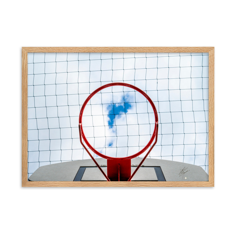 Vue en contre-plongée d'un panier de basket-ball, encadrant une échappée bleue dans un ciel nuageux, une interprétation artistique du jeu dans les cieux.