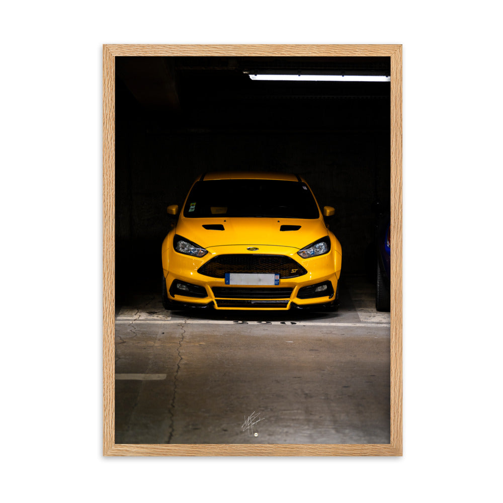 Vue frontale d'une Ford Focus ST en éclatant jaune, mise en lumière dans un parking souterrain avec un éclairage distinctif, encadrement en chêne.