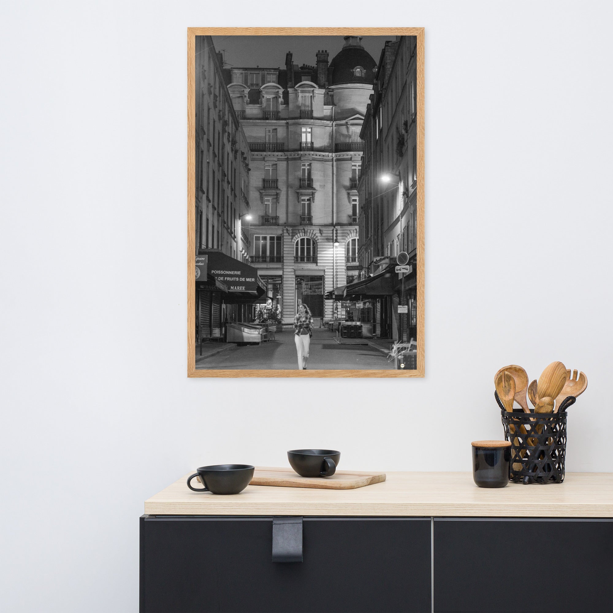 Photographie en noir et blanc d'une rue parisienne déserte la nuit, illuminée par les lumières douces des lampadaires, évoquant une atmosphère mystérieuse et mélancolique.