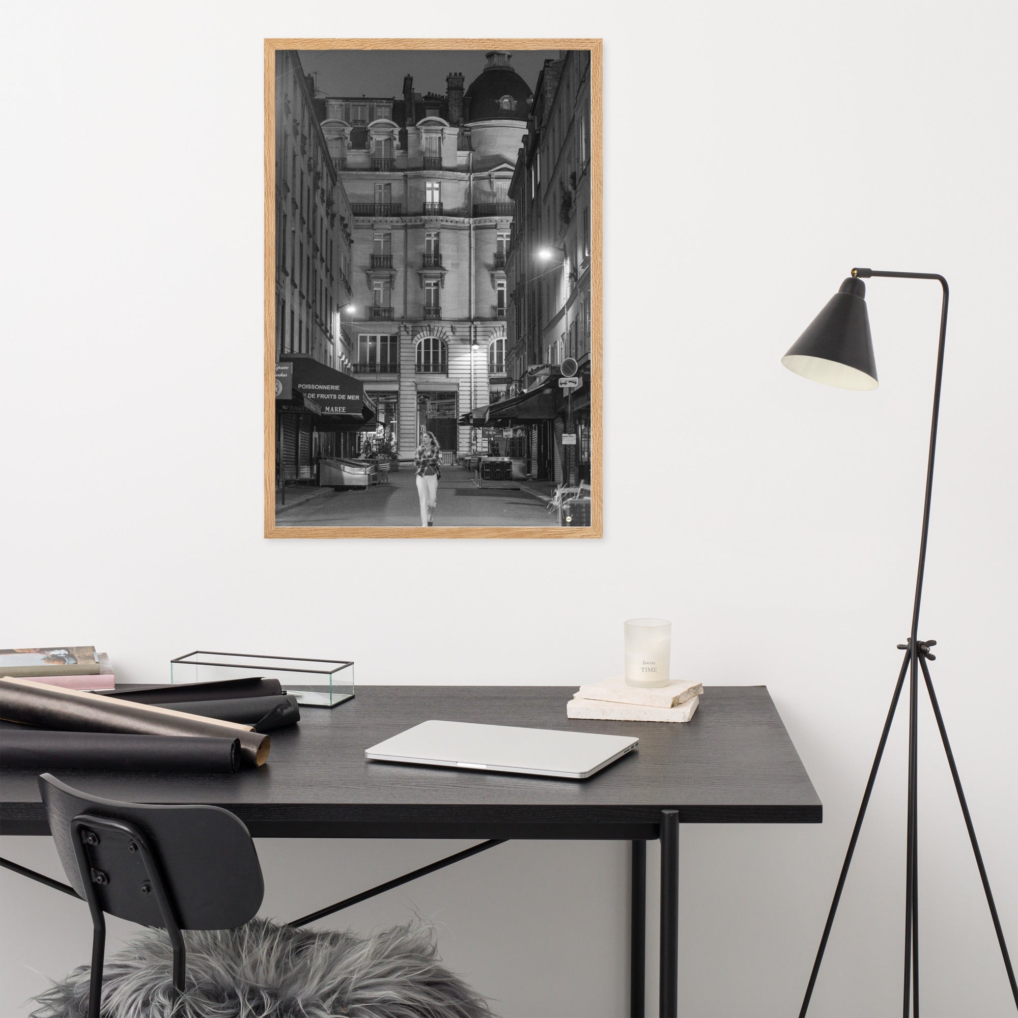 Photographie en noir et blanc d'une rue parisienne déserte la nuit, illuminée par les lumières douces des lampadaires, évoquant une atmosphère mystérieuse et mélancolique.