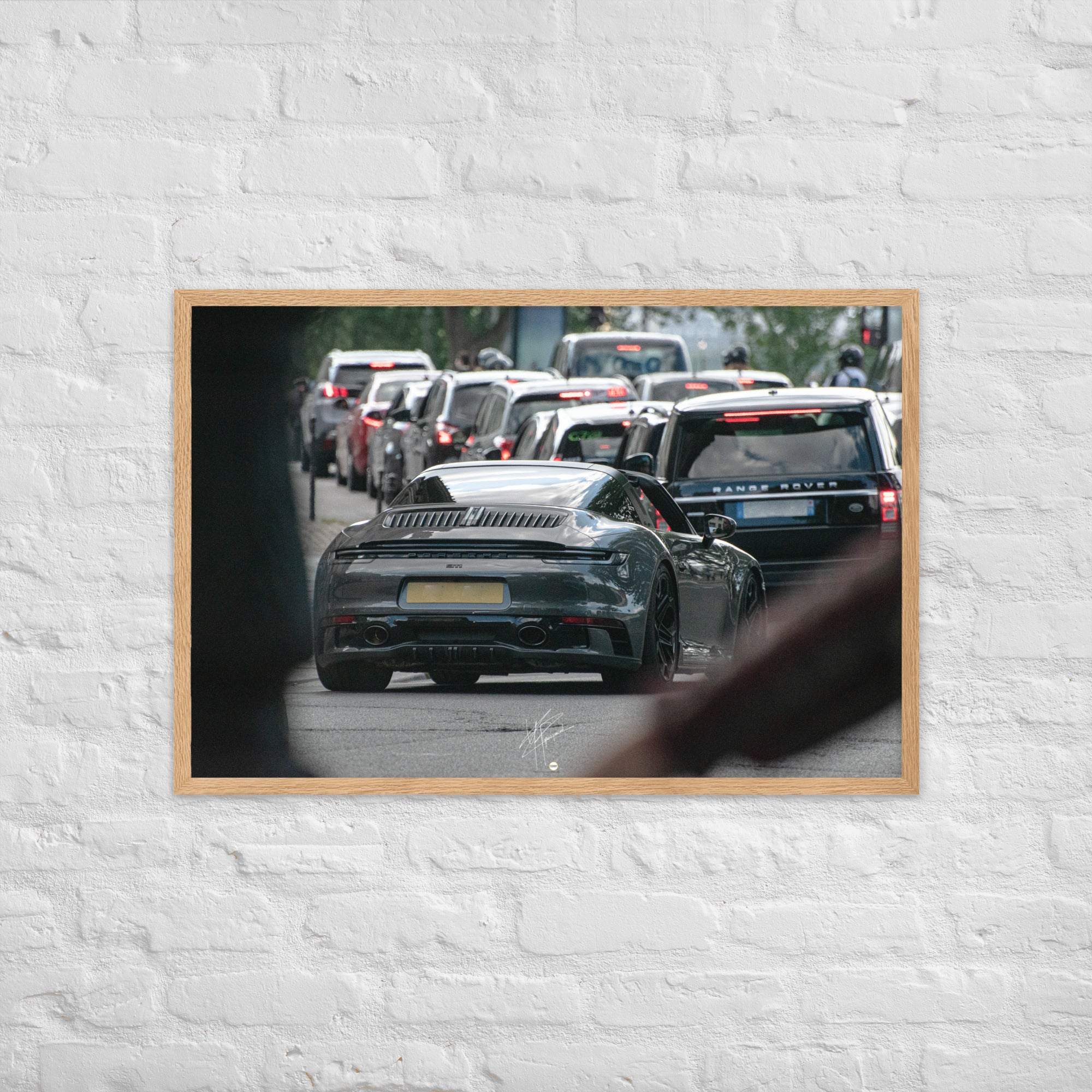 Photographie d'une Porsche 911 Targa vintage naviguant dans la circulation parisienne, suivie d'un Range Rover moderne, capturant une rencontre d'époques et de styles.