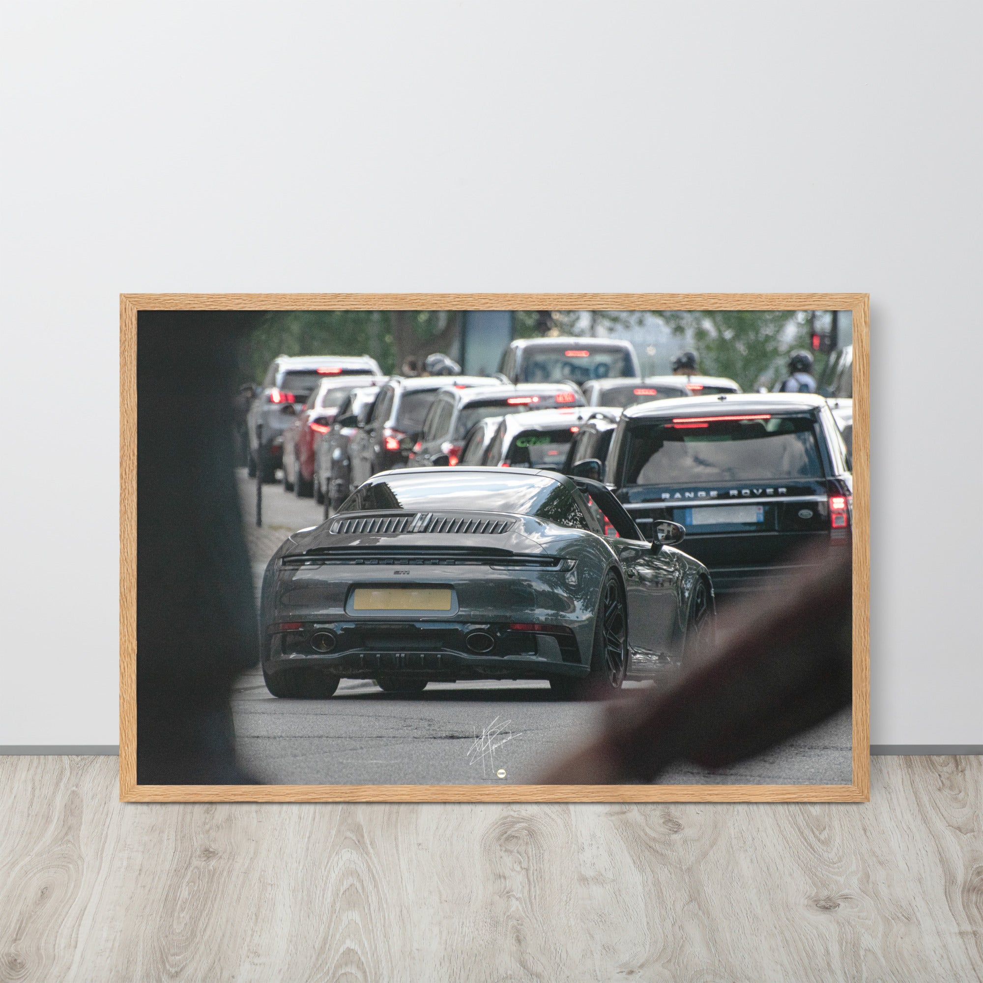 Photographie d'une Porsche 911 Targa vintage naviguant dans la circulation parisienne, suivie d'un Range Rover moderne, capturant une rencontre d'époques et de styles.