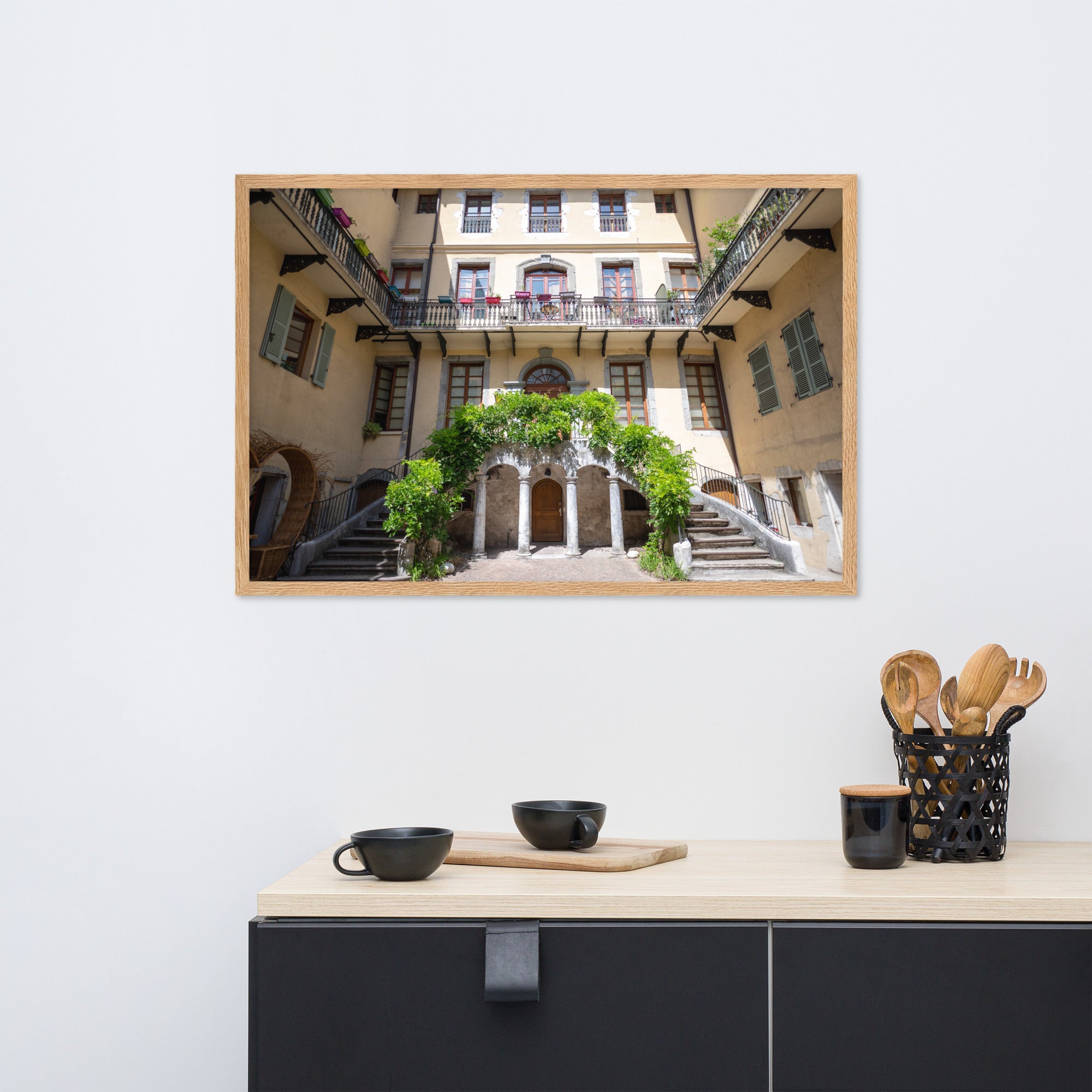 Photographie d'un bâtiment traditionnel italien avec escaliers en spirale et plantes suspendues, encadrée en chêne massif.