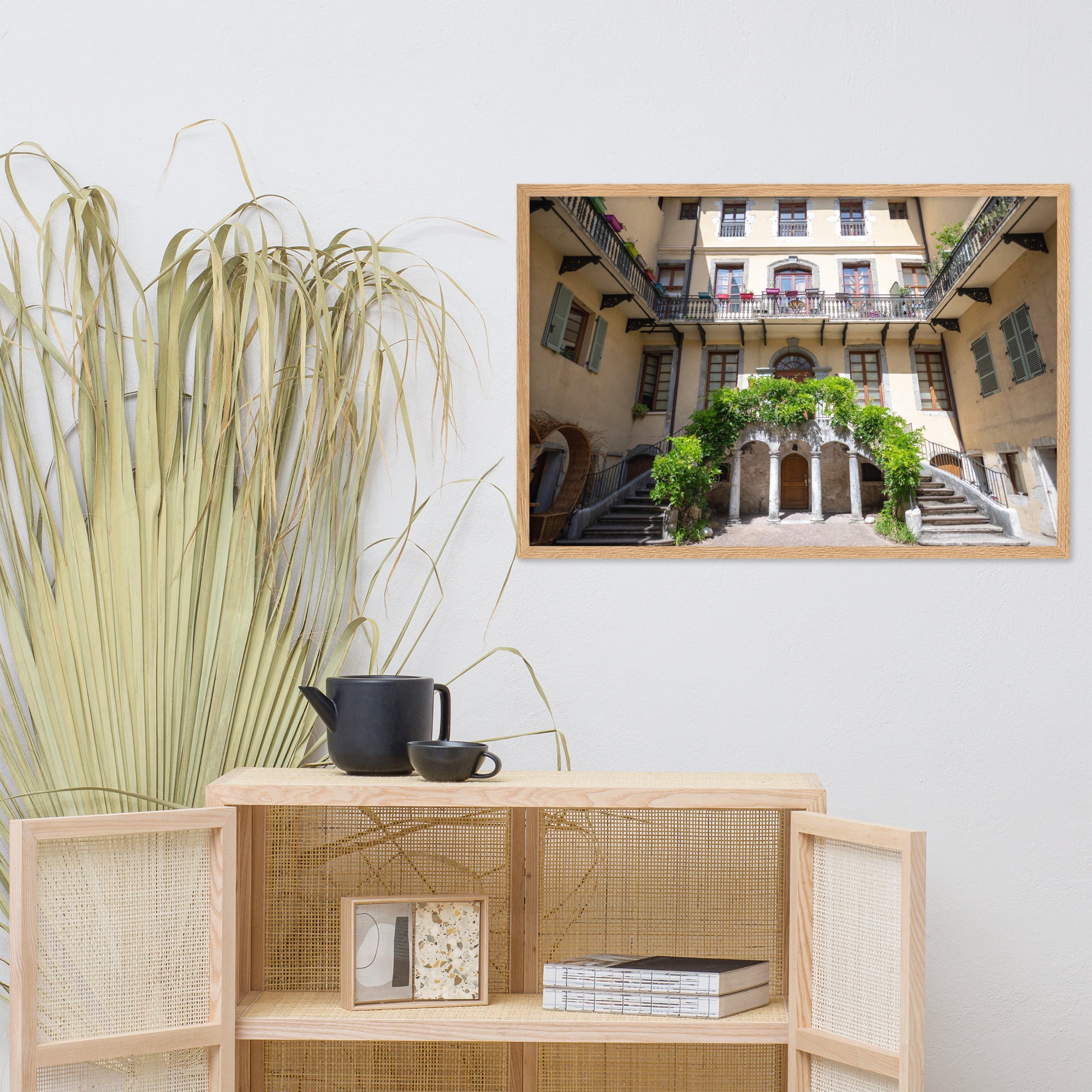 Photographie d'un bâtiment traditionnel italien avec escaliers en spirale et plantes suspendues, encadrée en chêne massif.