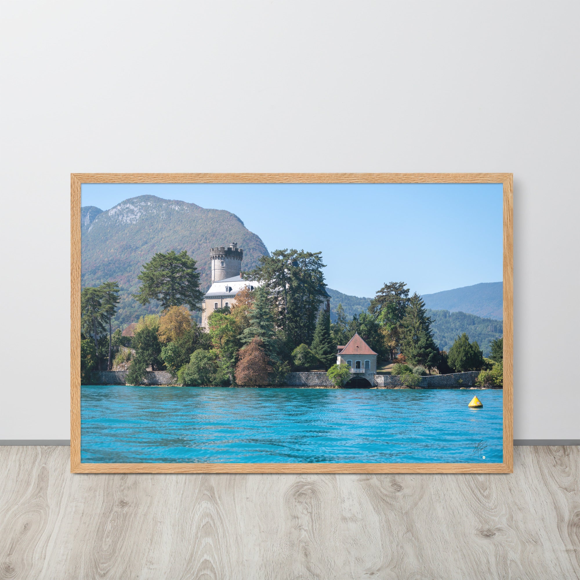 Vue panoramique du Château de Duingt, dominé par des montagnes, avec le Lac d'Annecy reflétant l'édifice, encadré en chêne.