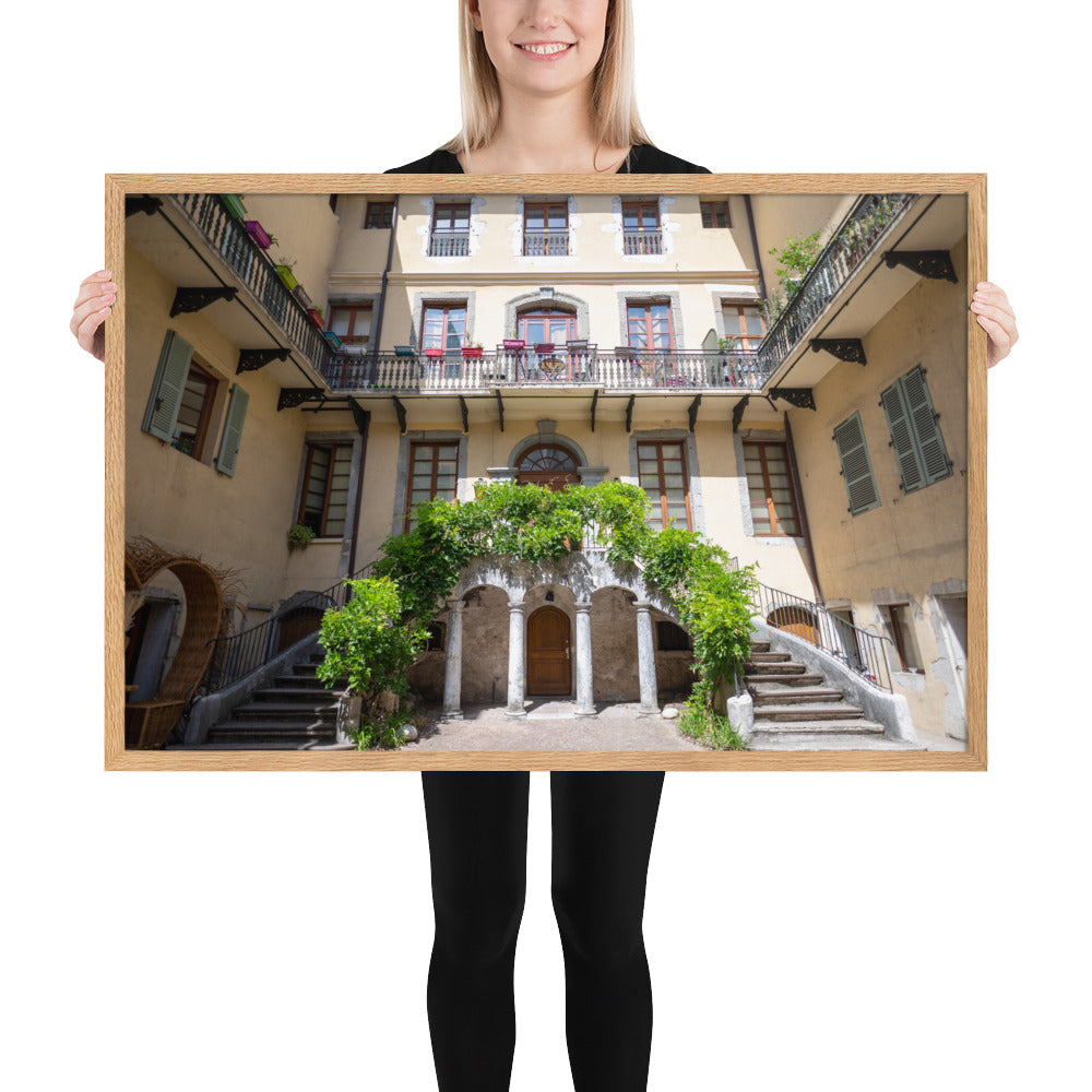 Photographie d'un bâtiment traditionnel italien avec escaliers en spirale et plantes suspendues, encadrée en chêne massif.